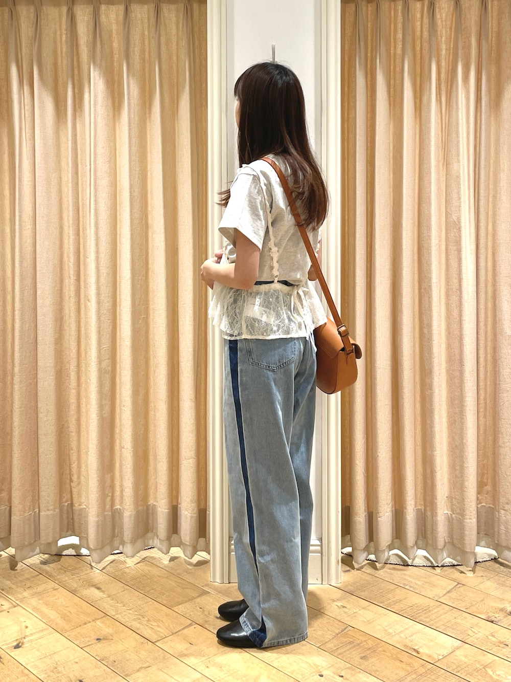 ブラック系のドレスシューズ、ブラウン系のハンドバッグ、ブルー系のその他パンツを着用したレディースの春コーディネートの2枚目の写真