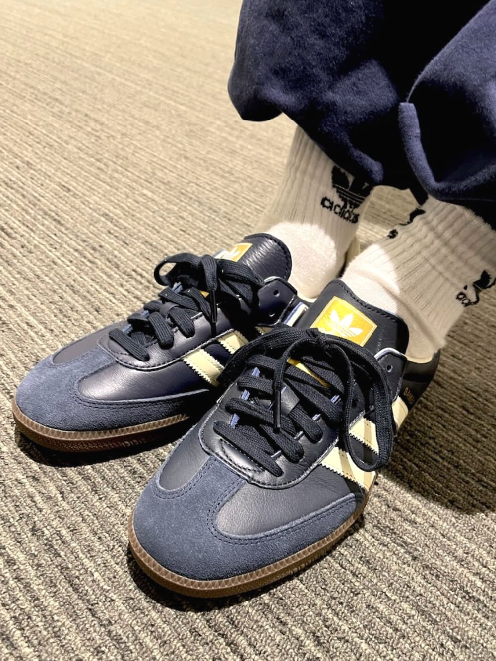 ホワイト系のポロシャツ、ブルー系のスニーカーを着用したメンズの秋コーディネートの4枚目の写真