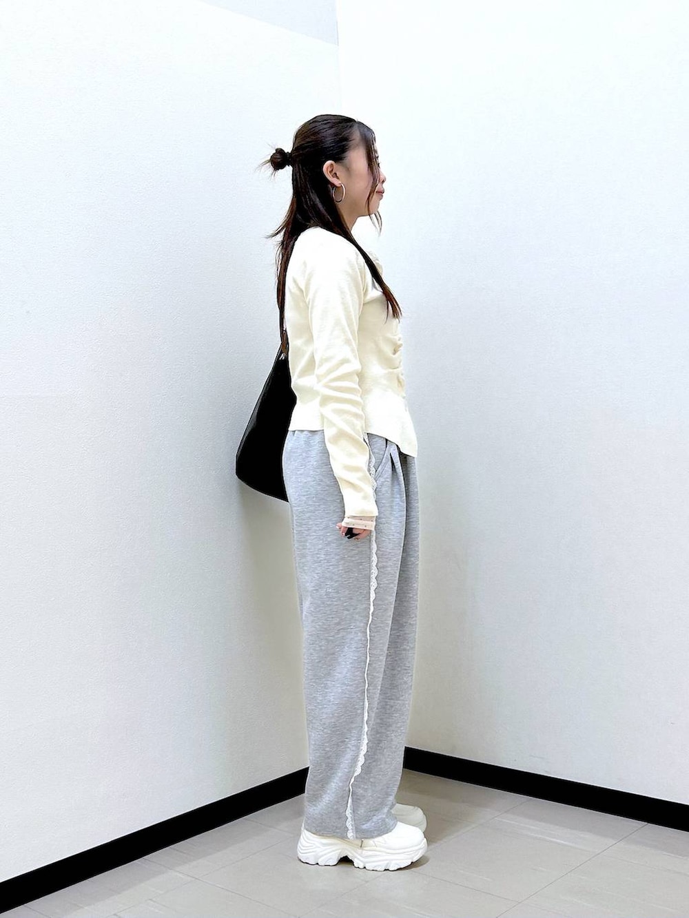 グレー系のスウェットパンツ、ホワイト系のTシャツ/カットソー、ホワイト系のスニーカーを着用したレディースの冬コーディネートの5枚目の写真