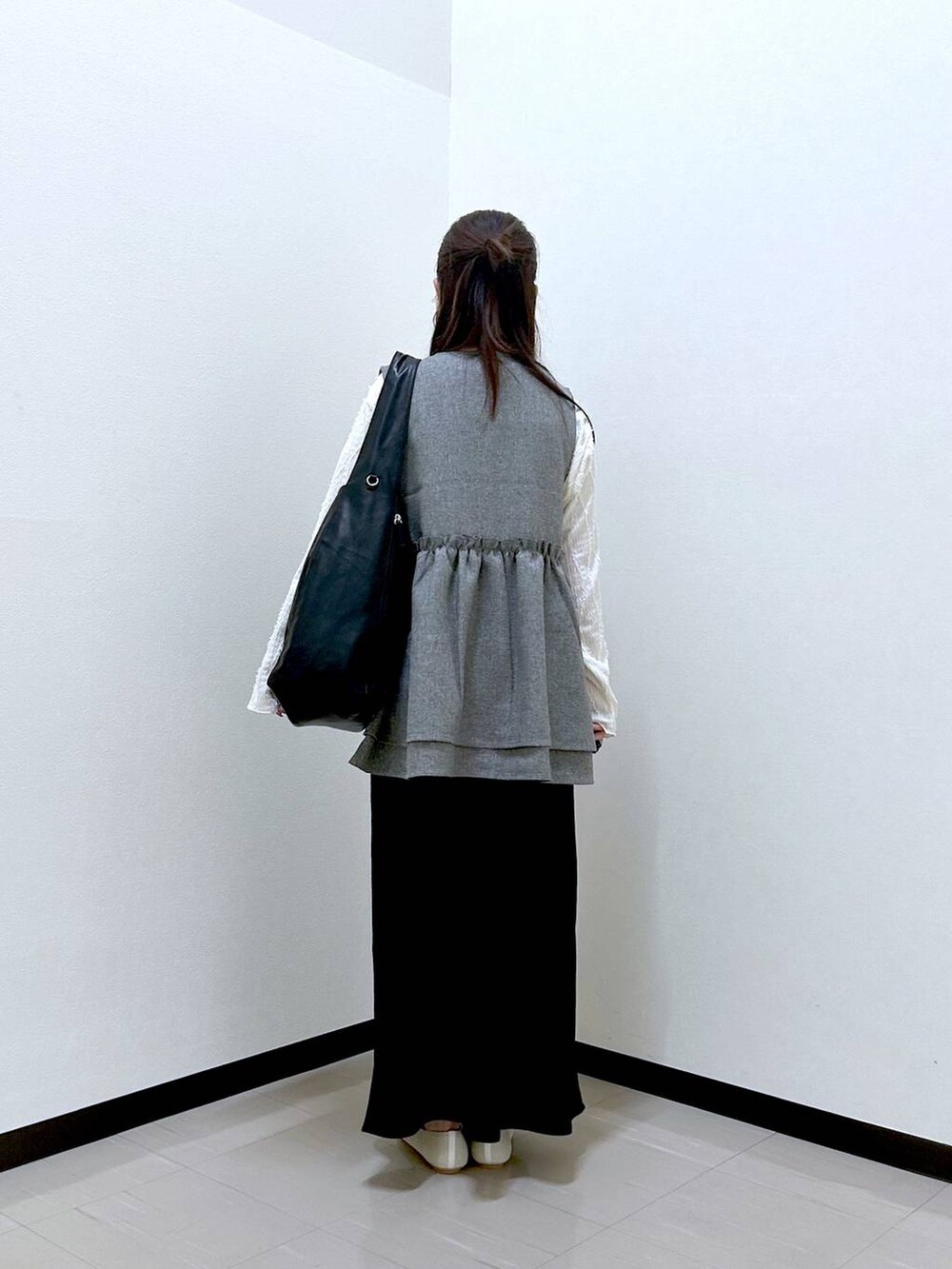 ベージュ系のTシャツ/カットソー、ブラック系のスカート、ホワイト系のパンプスを着用したレディースの春コーディネートの4枚目の写真