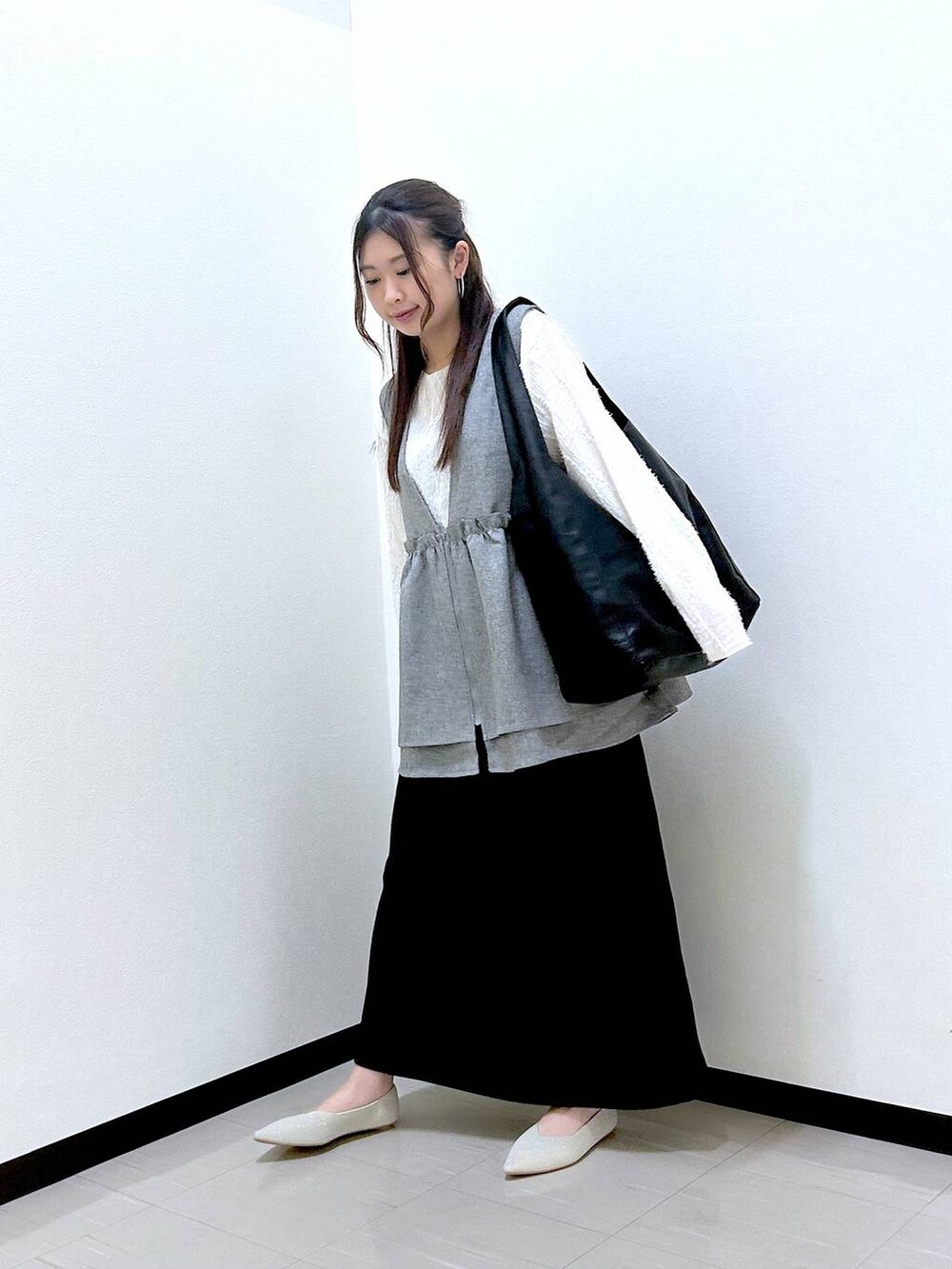 ベージュ系のTシャツ/カットソー、ブラック系のスカート、ホワイト系のパンプスを着用したレディースの春コーディネートの2枚目の写真