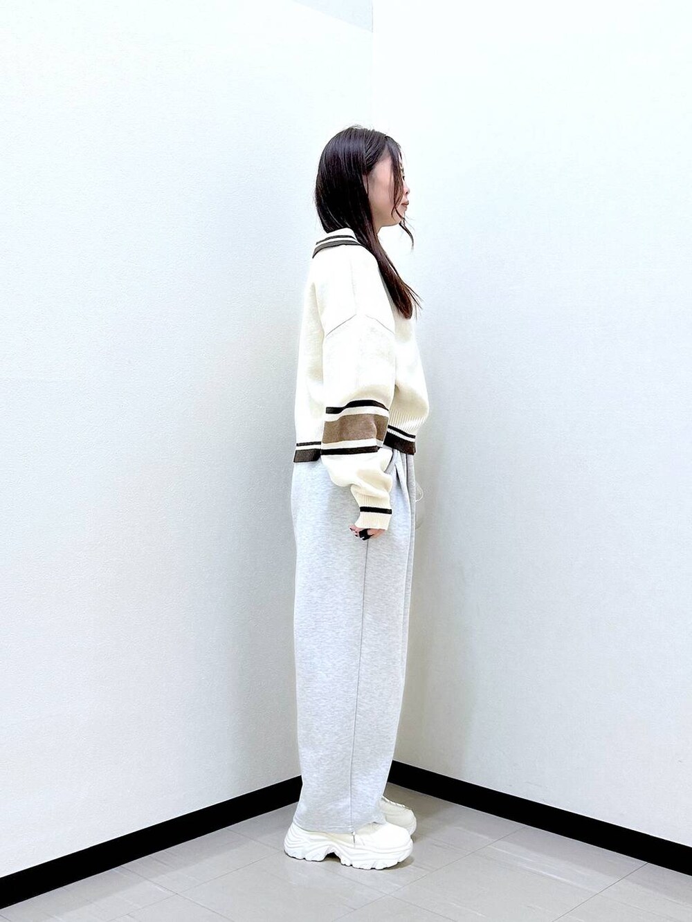 グレー系のスウェットパンツ、ホワイト系のボストンバッグ、ホワイト系のニット/セーターを着用したレディースの冬コーディネートの5枚目の写真