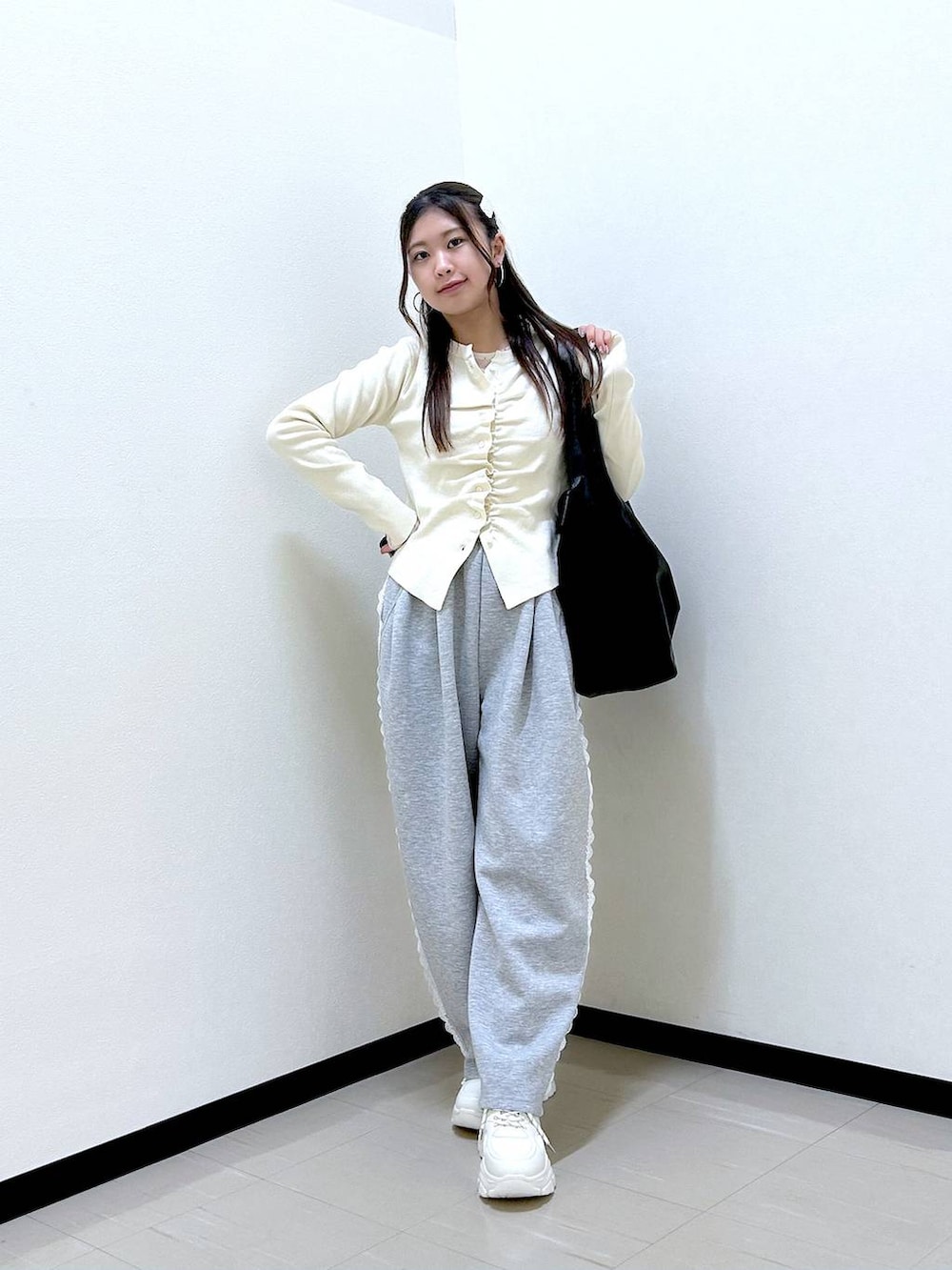 グレー系のスウェットパンツ、ホワイト系のTシャツ/カットソー、ホワイト系のスニーカーを着用したレディースの冬コーディネートの2枚目の写真