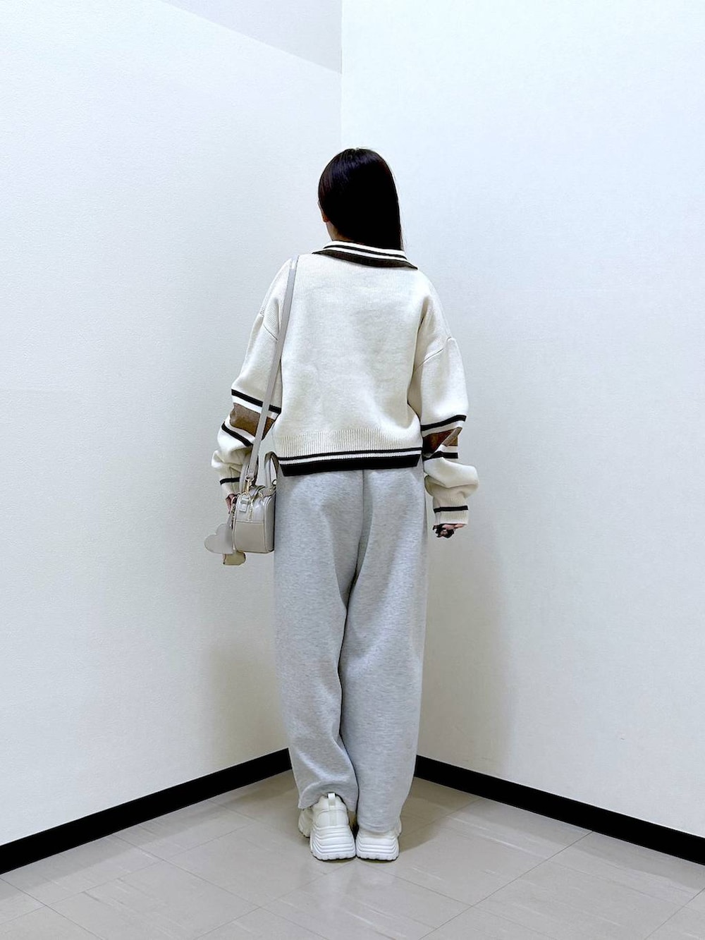 グレー系のスウェットパンツ、ホワイト系のボストンバッグ、ホワイト系のニット/セーターを着用したレディースの冬コーディネートの4枚目の写真