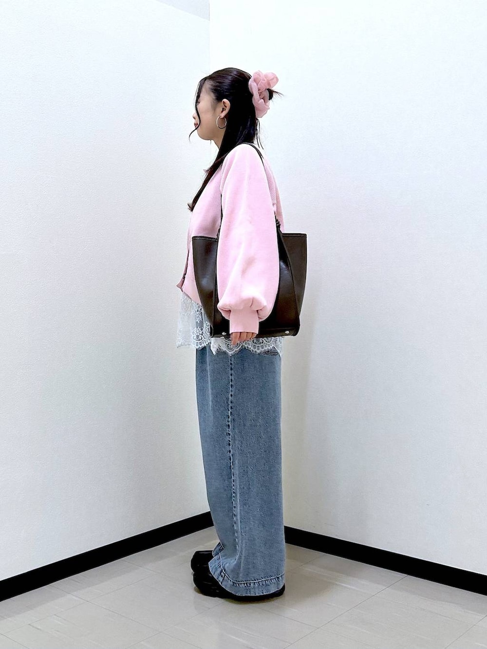 ブルー系のデニムパンツ、ブラック系のローファー、ブラウン系のトートバッグを着用したレディースの春コーディネートの3枚目の写真