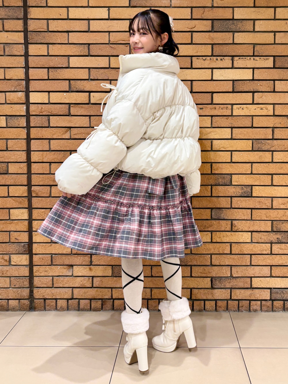 ホワイト系のジャケット/アウター、ピンク系のワンピース、ホワイト系のブーツを着用したレディースの冬コーディネートの2枚目の写真