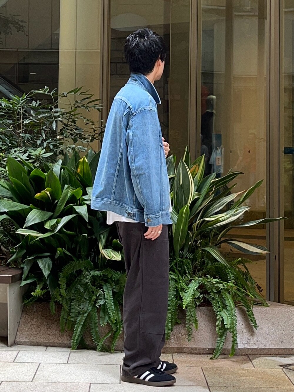 ブルー系のデニムジャケット、グレー系のその他パンツ、ブラック系のスニーカーを着用したメンズの秋コーディネートの2枚目の写真