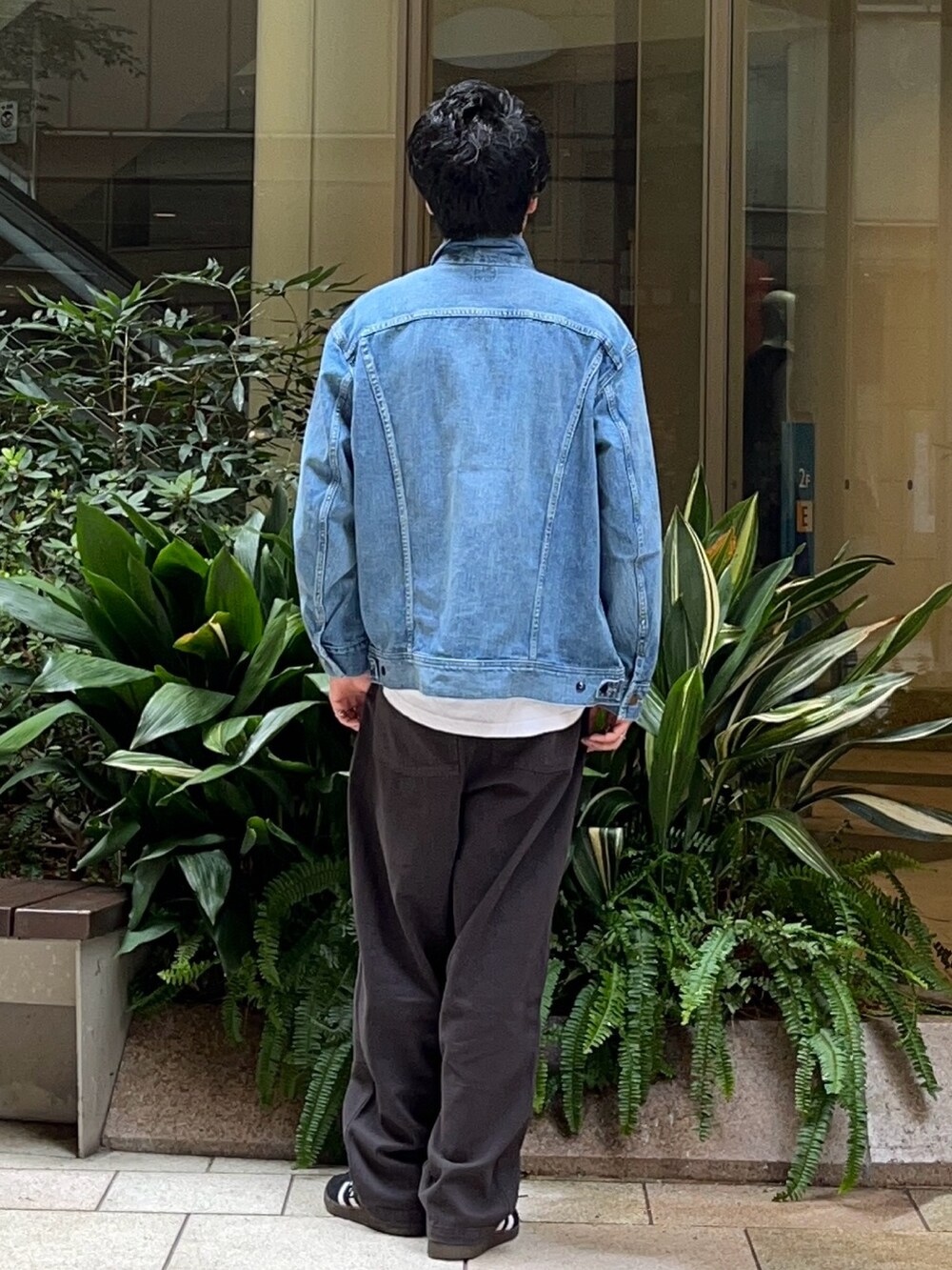 ブルー系のデニムジャケット、グレー系のその他パンツ、ブラック系のスニーカーを着用したメンズの秋コーディネートの3枚目の写真