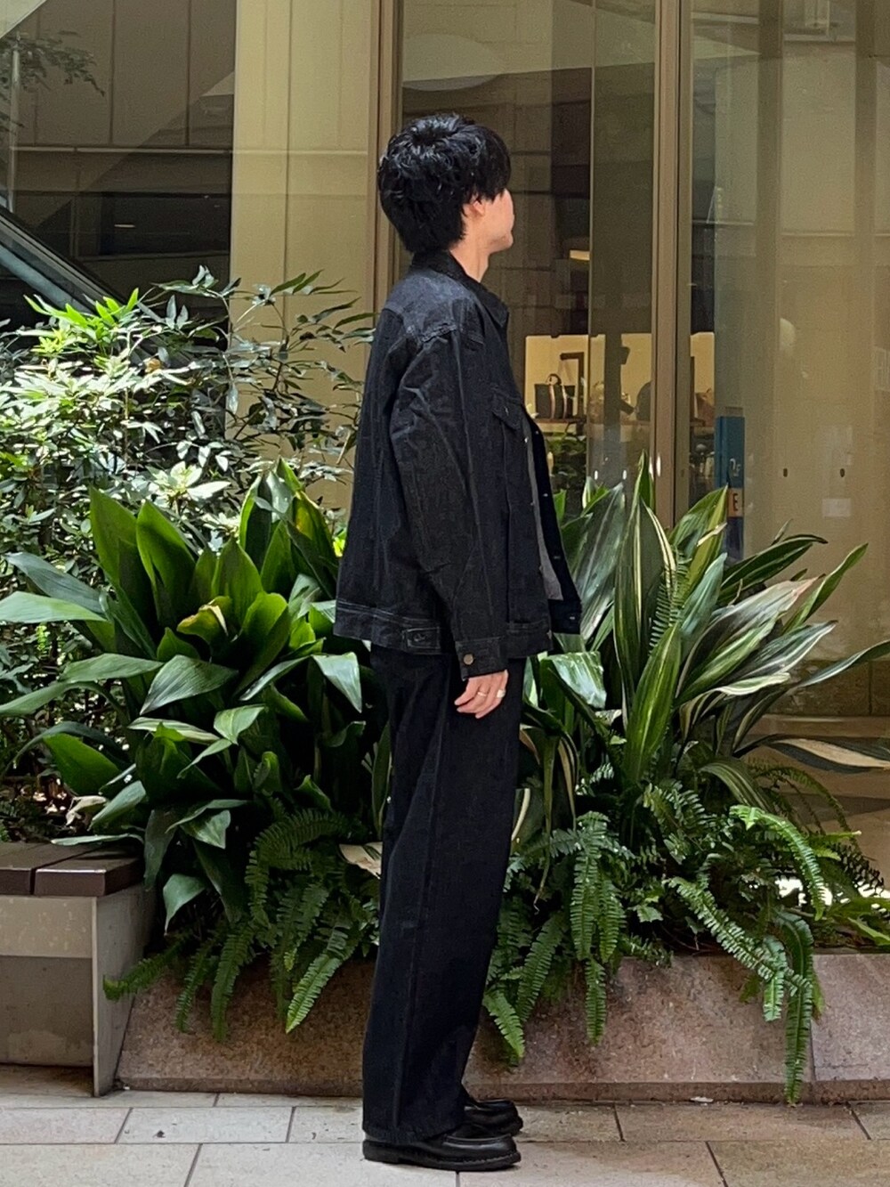 ブラック系のデニムジャケット、ブラック系のデニムパンツ、ブラック系のローファーを着用したメンズの秋コーディネートの2枚目の写真