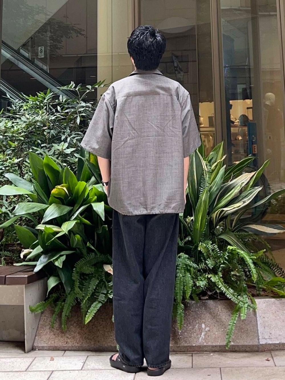 ブラック系のサンダル、ブラック系のデニムパンツ、グレー系のシャツ/ブラウスを着用したメンズの夏コーディネートの3枚目の写真