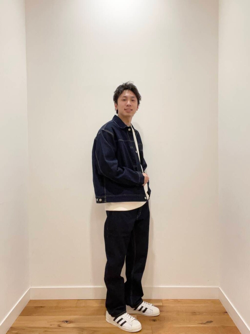 ホワイト系のスウェット、ブルー系のデニムパンツ、ブルー系のデニムジャケットを着用したメンズの冬コーディネートの2枚目の写真