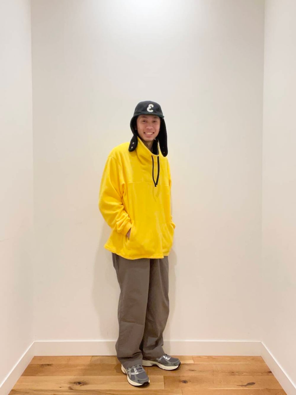 グレー系のその他パンツ、グレー系のスニーカー、イエロー系のTシャツ/カットソーを着用したメンズの冬コーディネートの3枚目の写真