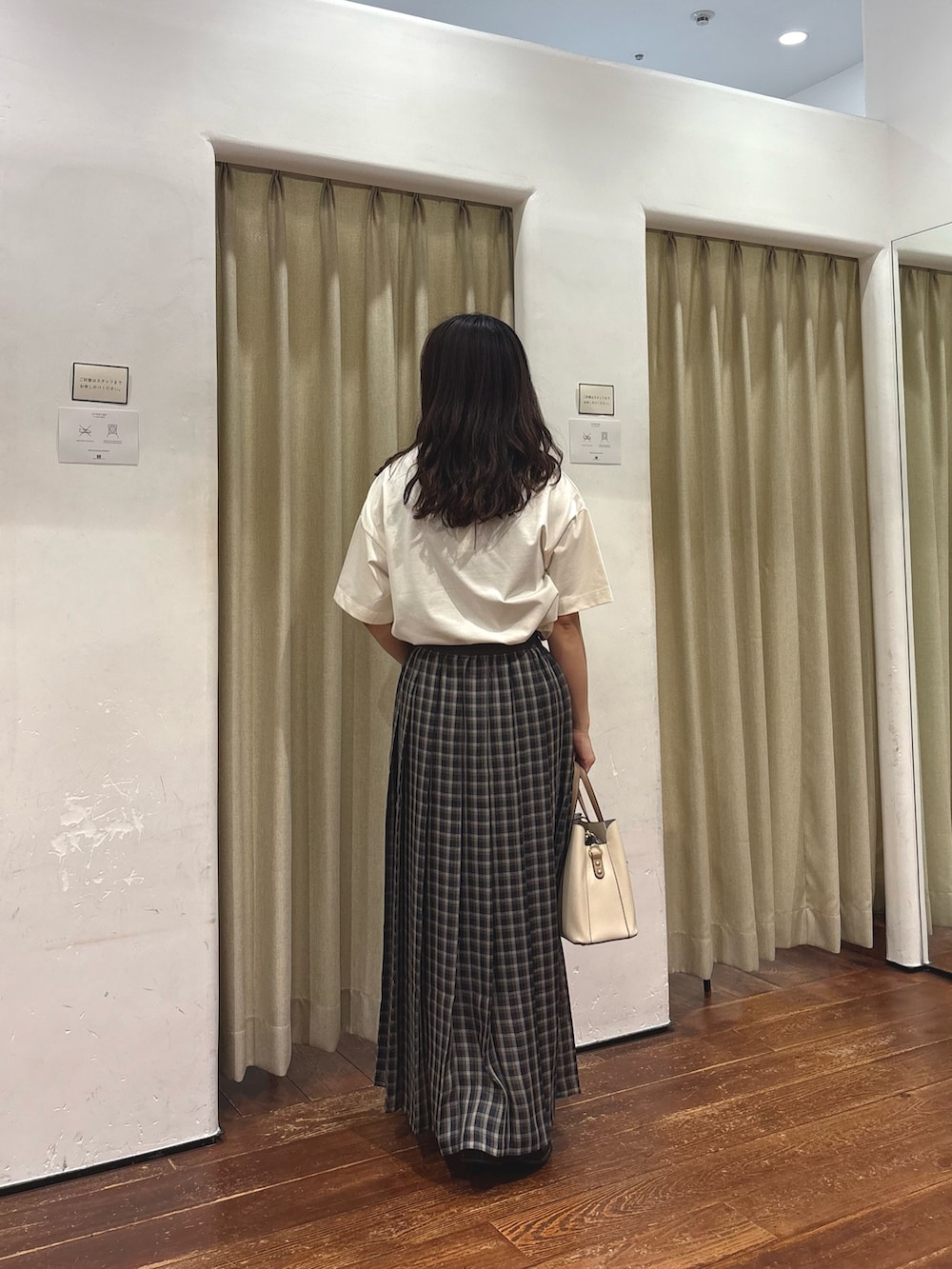 ブラック系のトートバッグ、ホワイト系のTシャツ/カットソー、ゴールド系のネックレスを着用したレディースの夏コーディネートの3枚目の写真