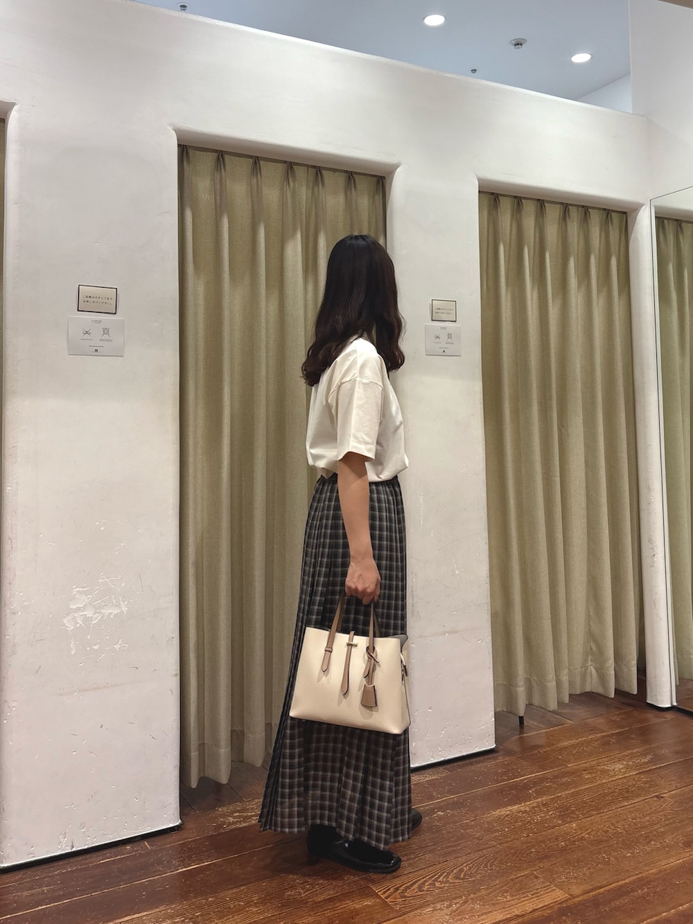 ブラック系のトートバッグ、ホワイト系のTシャツ/カットソー、ゴールド系のネックレスを着用したレディースの夏コーディネートの2枚目の写真