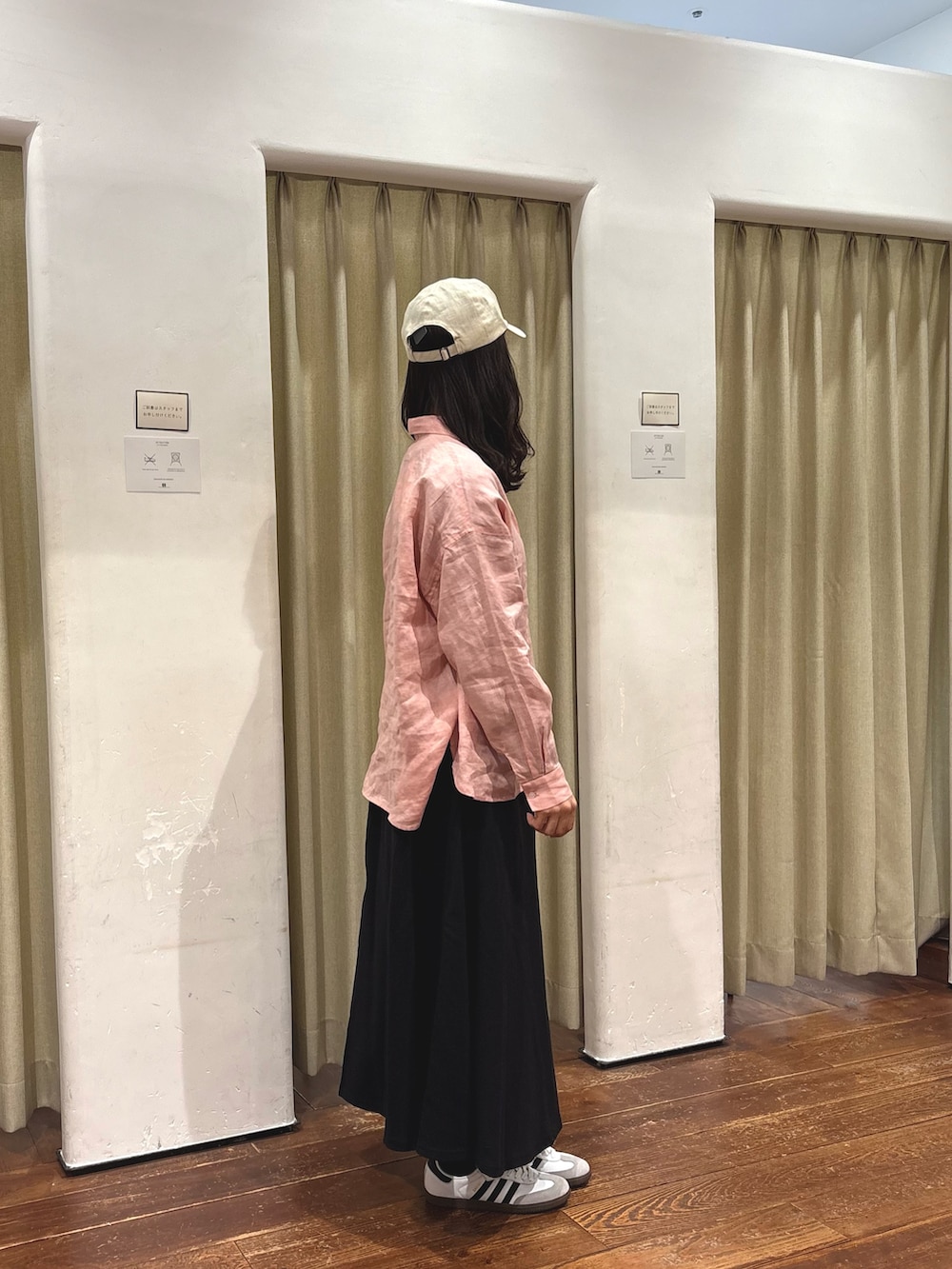 ピンク系のシャツ/ブラウス、ブラック系のスカート、ホワイト系のスニーカーを着用したレディースの春コーディネートの2枚目の写真