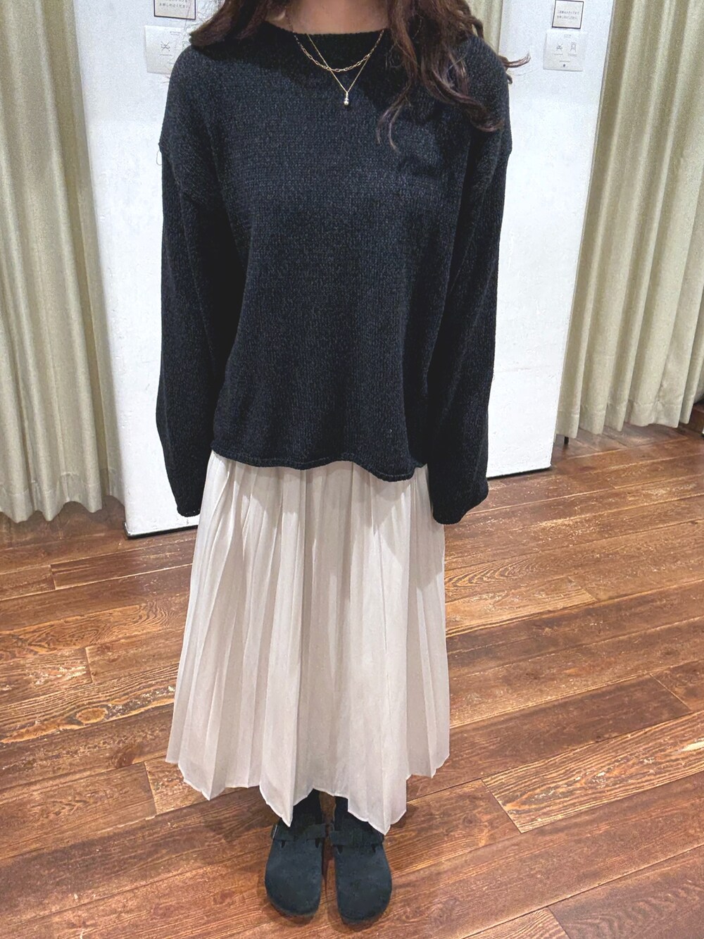 ホワイト系のスカート、ブラック系のサンダル、ブラック系のニット/セーターを着用したレディースの秋コーディネートの5枚目の写真