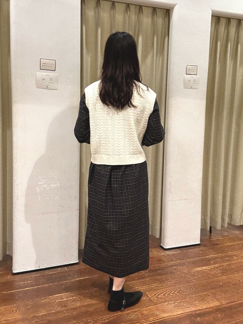 ブラック系のワンピース、ホワイト系のベストを着用したレディースの秋コーディネートの2枚目の写真