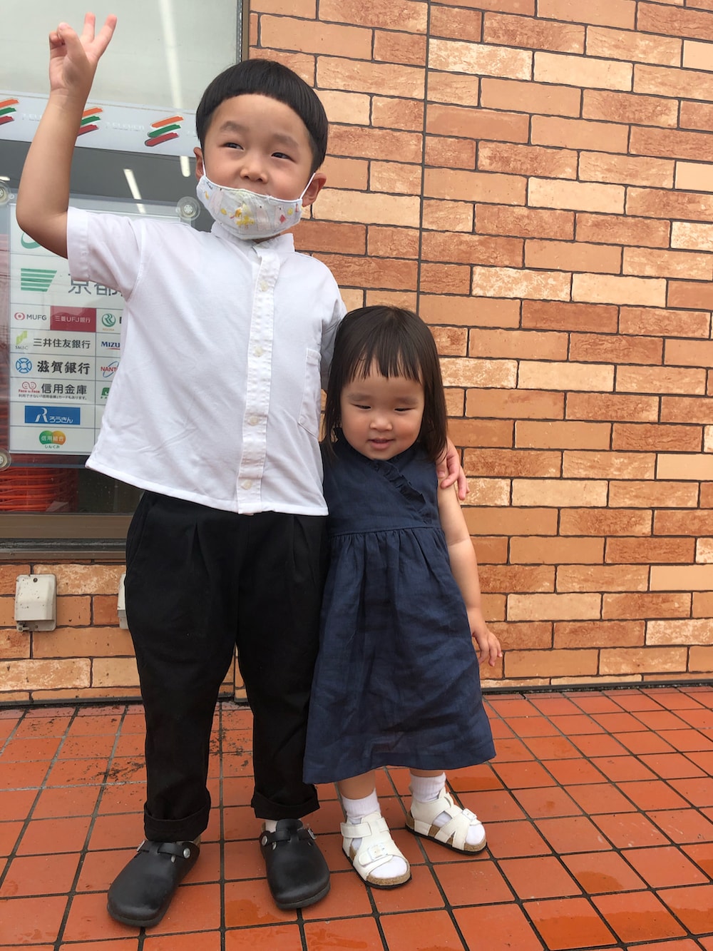 ブラック系のワンピース、ホワイト系のサンダル、ホワイト系のシャツ/ブラウスを着用したキッズの秋コーディネートの2枚目の写真