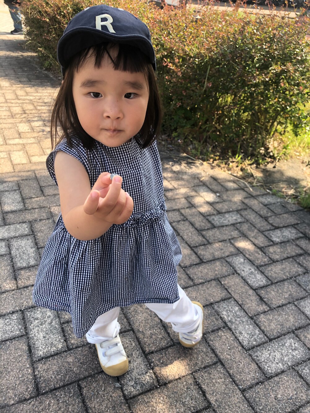 ブルー系のワンピース、ホワイト系のパンツ、ホワイト系のスニーカーを着用したキッズの春コーディネートの2枚目の写真