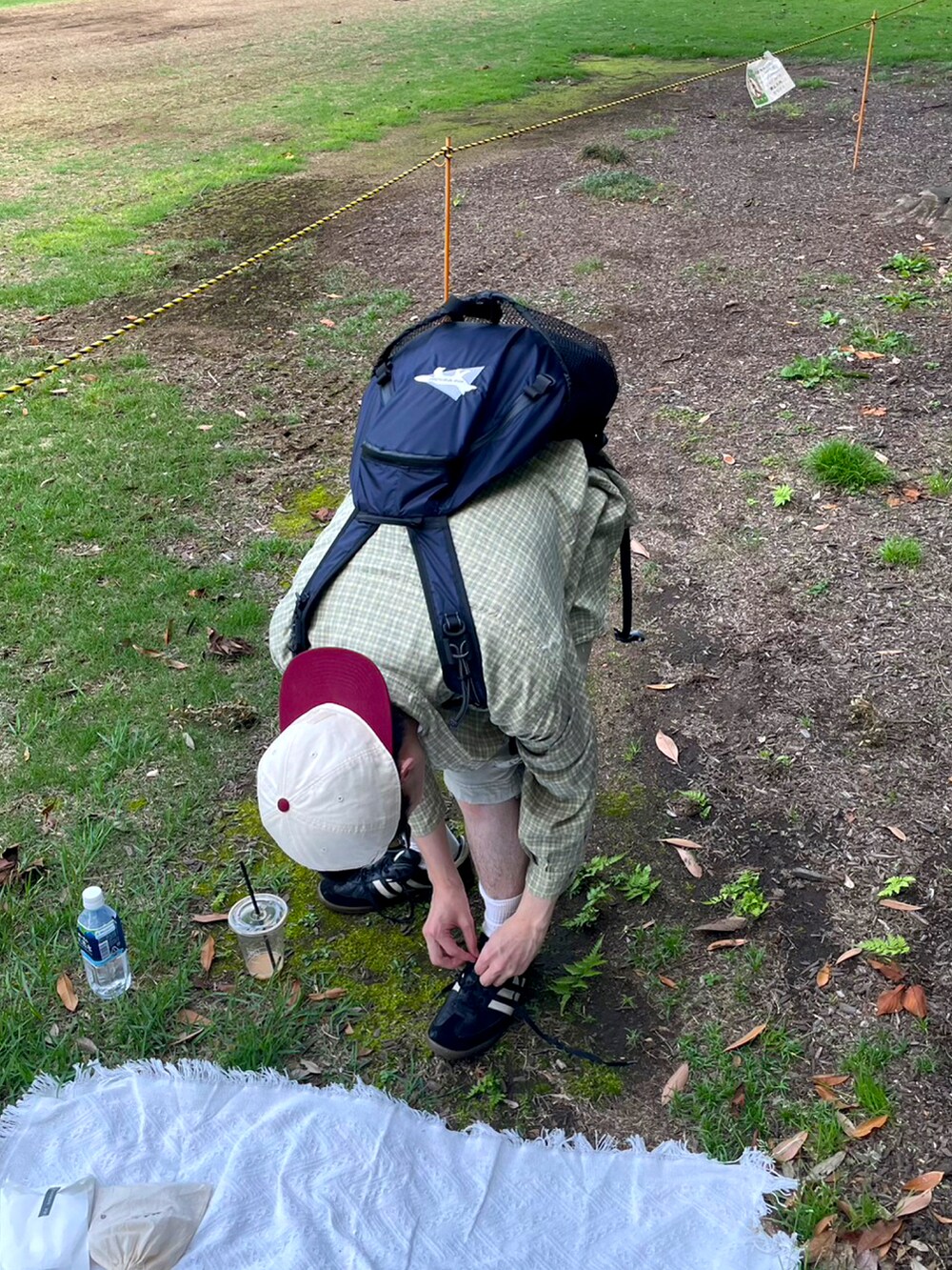 ブラック系のスニーカー、グレー系のTシャツ/カットソー、ブルー系のバックパック/リュックを着用したメンズの春コーディネートの2枚目の写真