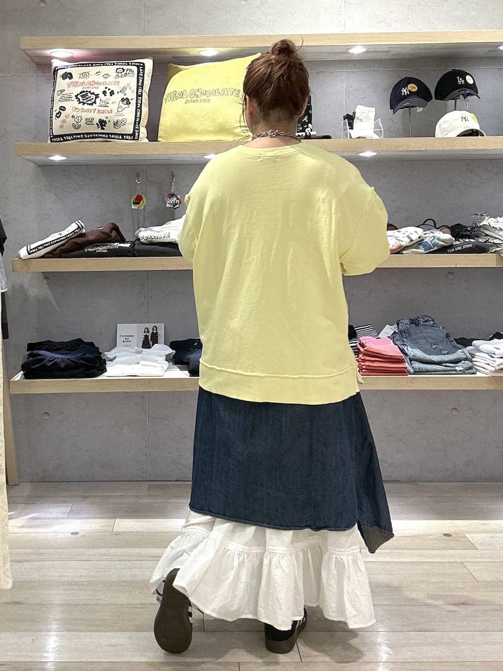 イエロー系のスウェット、ホワイト系のスカートを着用したレディースの冬コーディネートの2枚目の写真