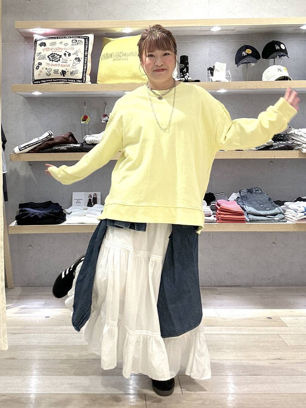 イエロー系のスウェット、ホワイト系のスカートを着用したレディースの冬コーディネートの3枚目の写真