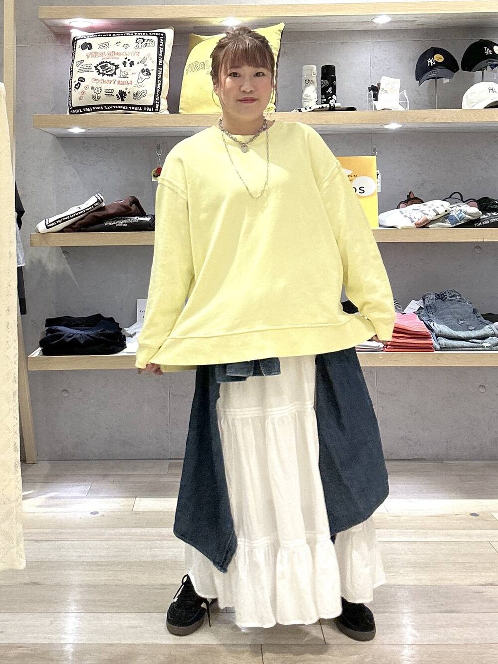 イエロー系のスウェット、ホワイト系のスカートを着用したレディースの冬コーディネートの4枚目の写真