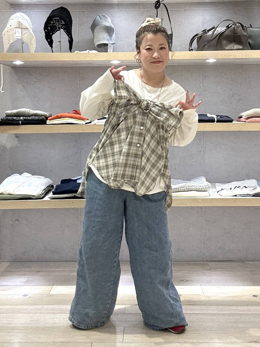 ブルー系のデニムパンツ、レッド系のスニーカー、ホワイト系のTシャツ/カットソーを着用したレディースの春コーディネートの4枚目の写真