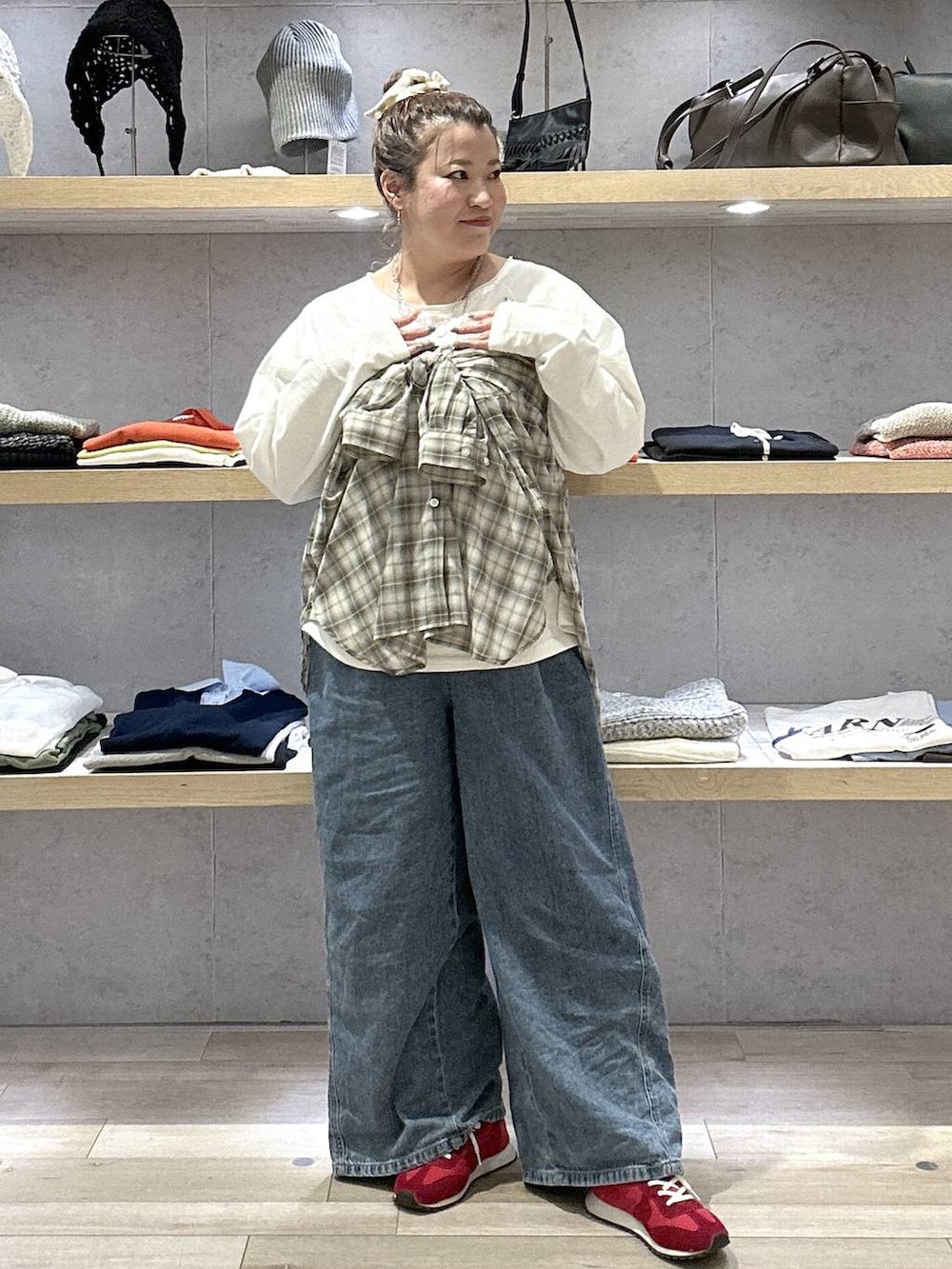 ブルー系のデニムパンツ、レッド系のスニーカー、ホワイト系のTシャツ/カットソーを着用したレディースの春コーディネートの5枚目の写真