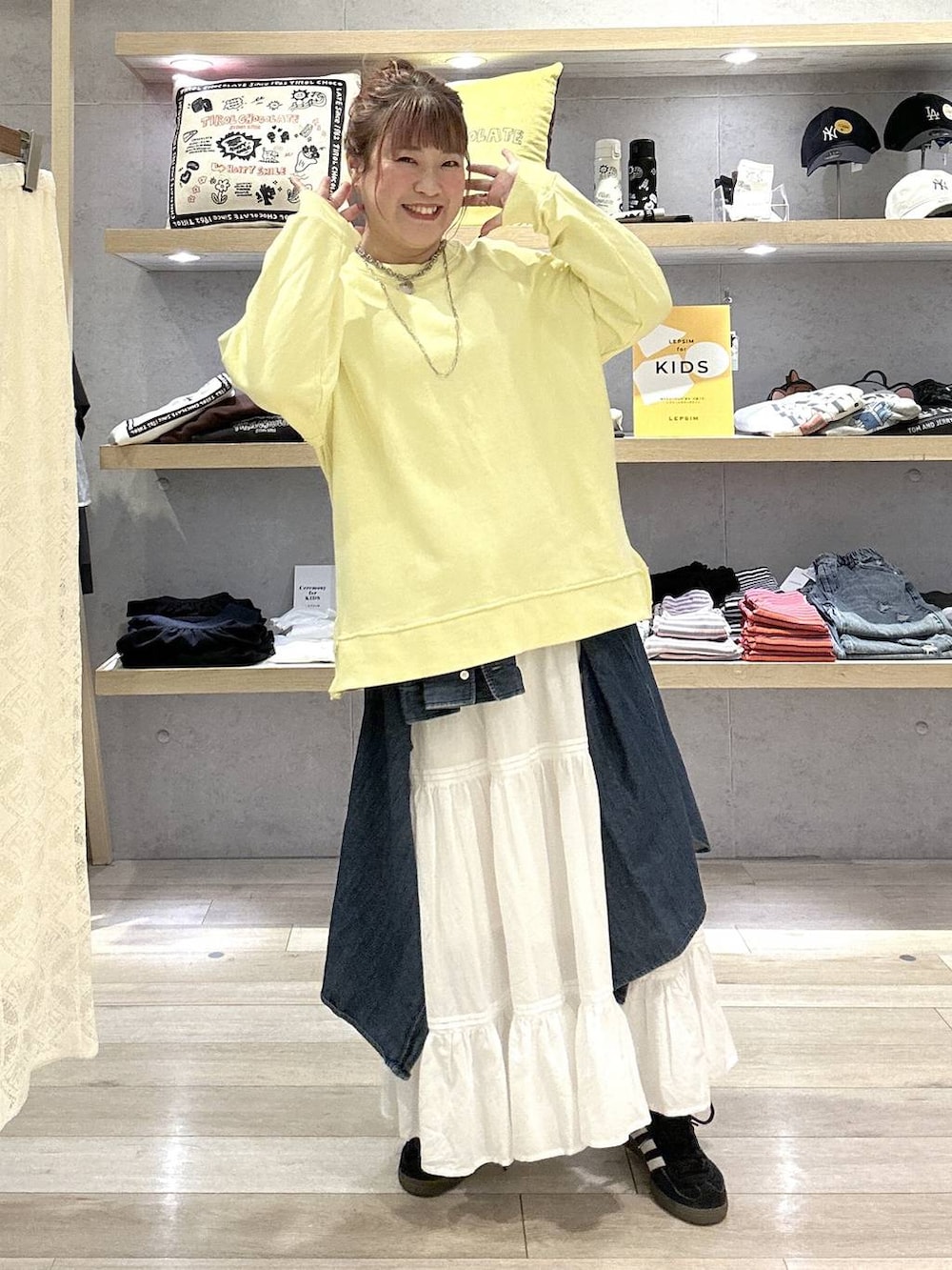 イエロー系のスウェット、ホワイト系のスカートを着用したレディースの冬コーディネートの5枚目の写真