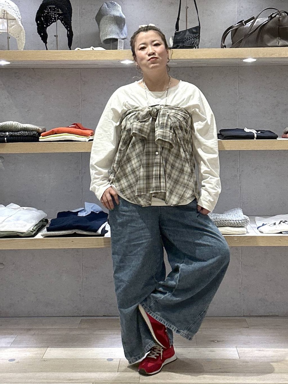 ブルー系のデニムパンツ、レッド系のスニーカー、ホワイト系のTシャツ/カットソーを着用したレディースの春コーディネートの3枚目の写真