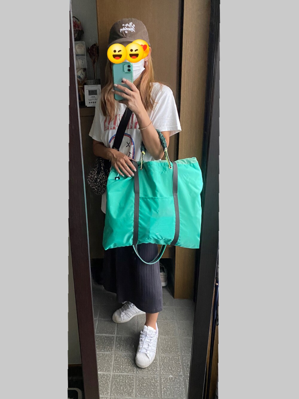 ホワイト系のスニーカー、グリーン系のスカート、グリーン系のトートバッグを着用したレディースの秋コーディネートの2枚目の写真