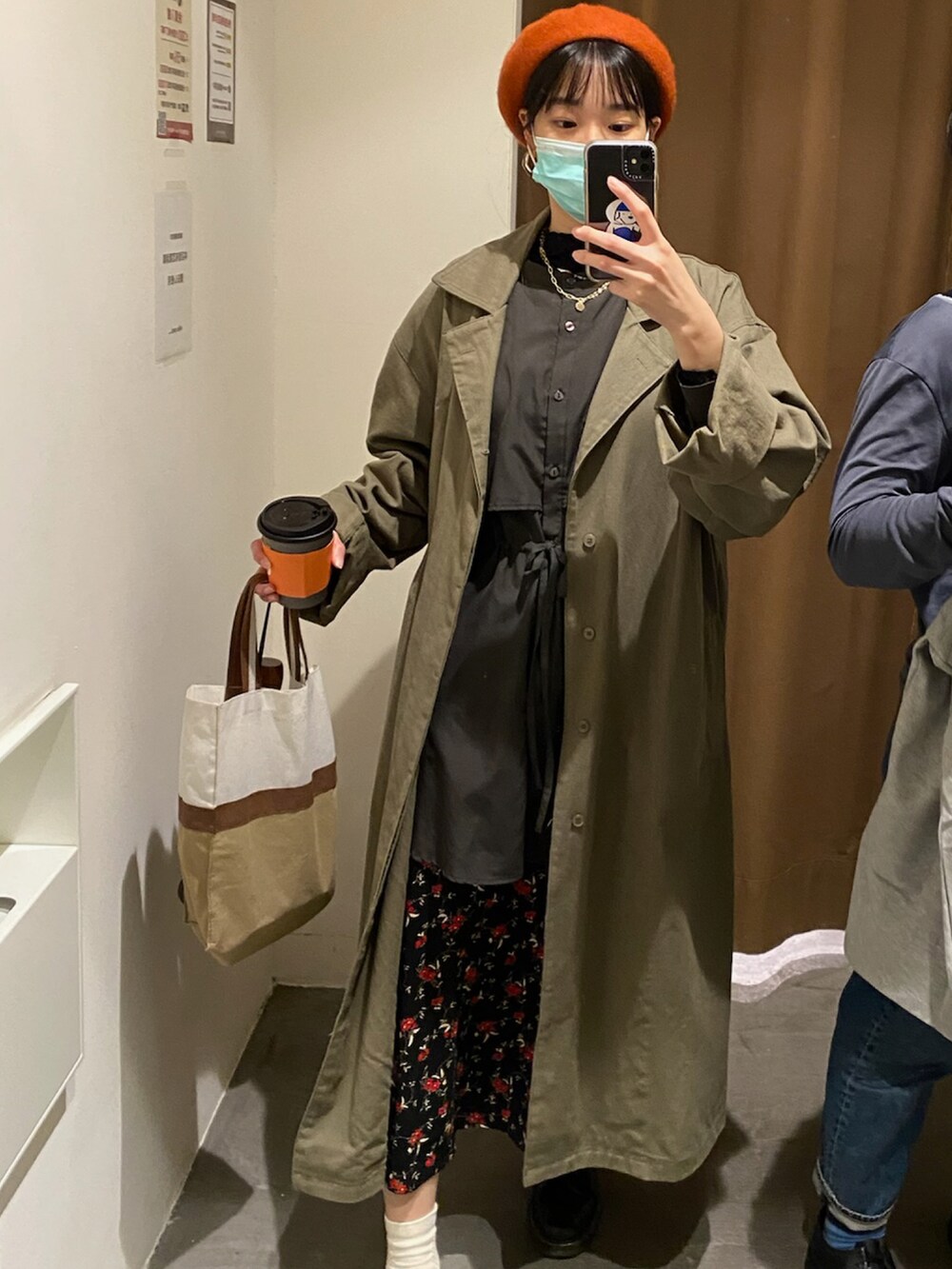 グリーン系のチェスターコート、ブラック系のシャツ/ブラウス、ブラック系のローファーを着用したレディースの冬コーディネートの2枚目の写真