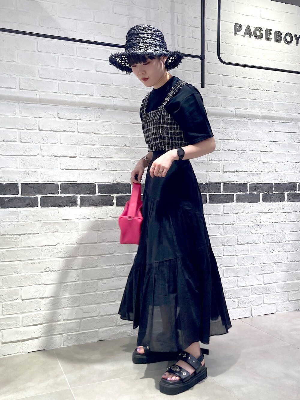 ピンク系のショルダーバッグ、ブラック系のその他トップス、ブラック系のTシャツ/カットソーを着用したレディースの夏コーディネートの2枚目の写真