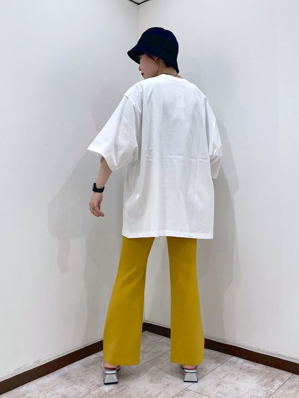 ホワイト系のTシャツ/カットソー、イエロー系のスラックス、シルバー系のサンダルを着用したレディースの夏コーディネートの4枚目の写真