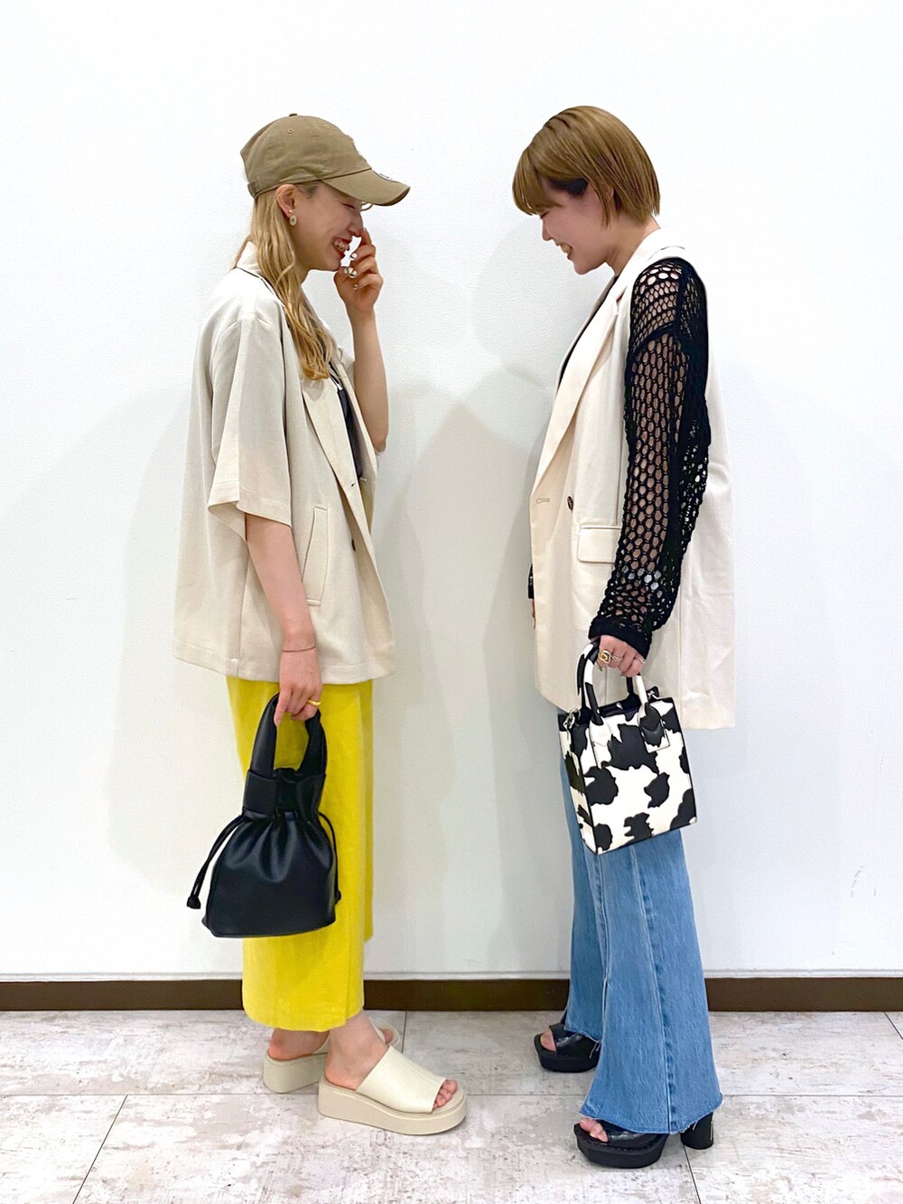 ホワイト系のその他アウター、ブラック系のニット/セーター、ホワイト系のショルダーバッグを着用したレディースの春コーディネートの2枚目の写真