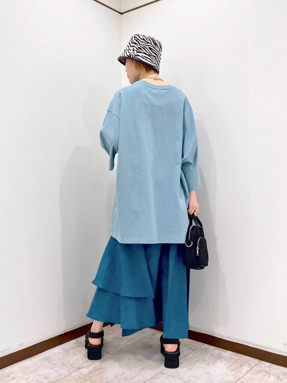 ブルー系のTシャツ/カットソー、ブラック系のショルダーバッグ、ブルー系のスカートを着用したレディースの春コーディネートの5枚目の写真