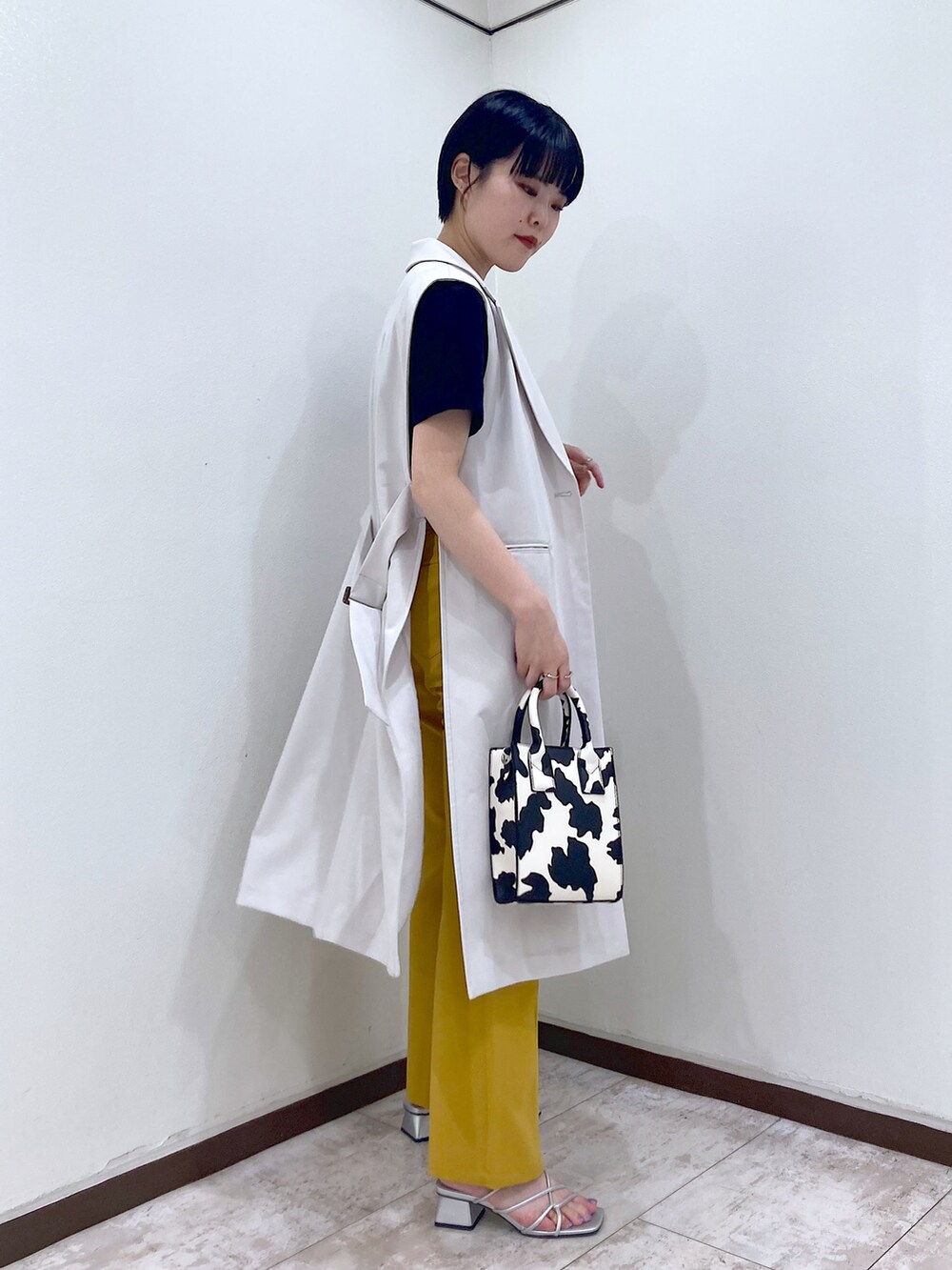 ブラック系のTシャツ/カットソー、ベージュ系のその他アウター、イエロー系のスラックスを着用したレディースの夏コーディネートの4枚目の写真