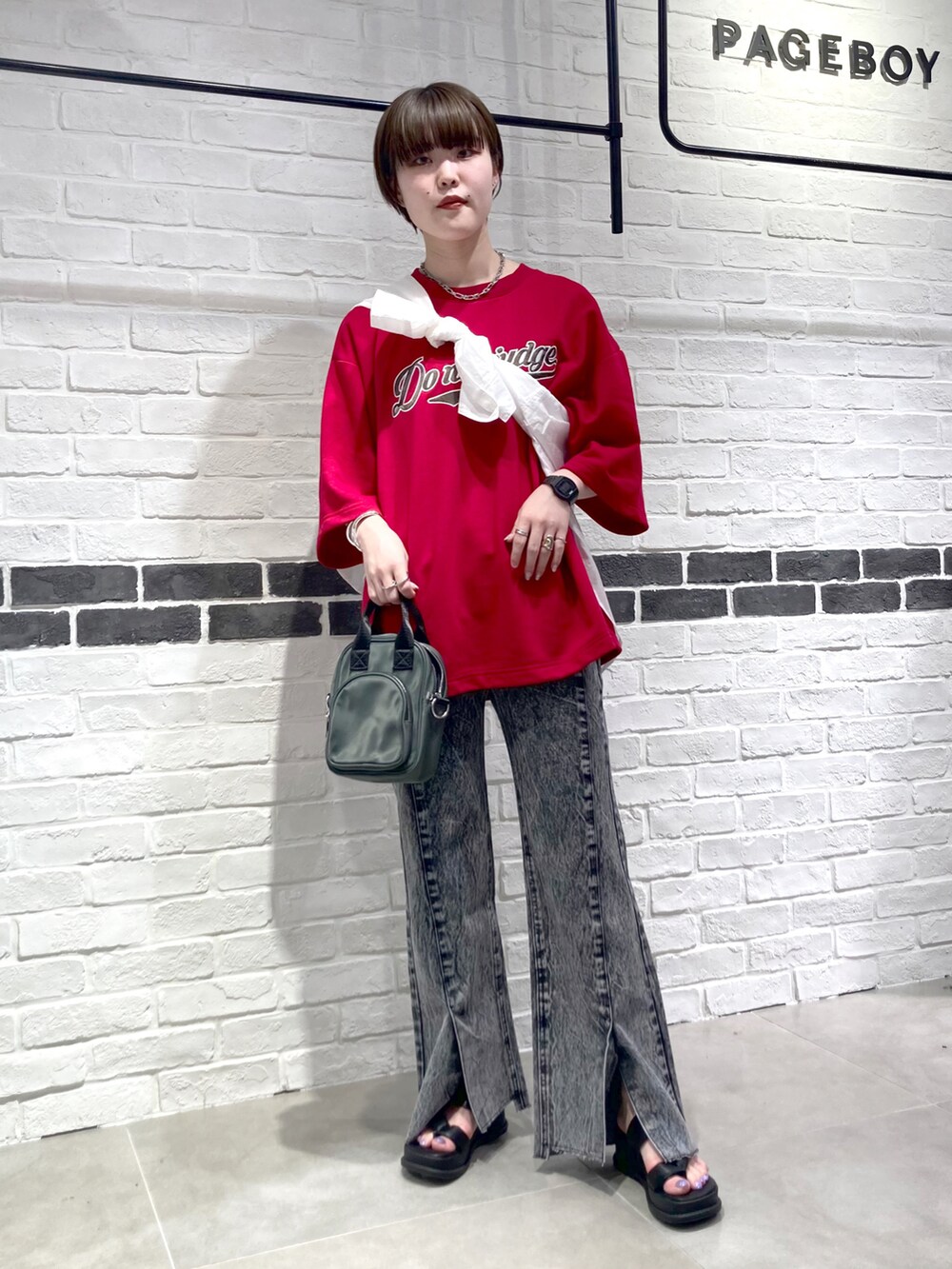 レッド系のTシャツ/カットソー、ホワイト系のシャツ/ブラウス、ブラック系のショルダーバッグを着用したレディースの夏コーディネートの2枚目の写真