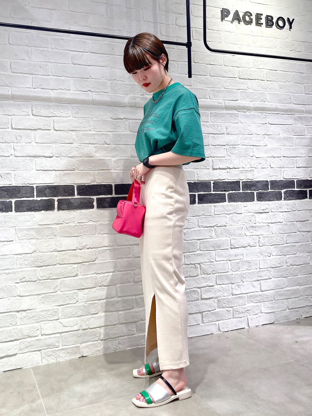 グリーン系のTシャツ/カットソー、ピンク系のショルダーバッグ、ホワイト系のスカートを着用したレディースの夏コーディネートの2枚目の写真