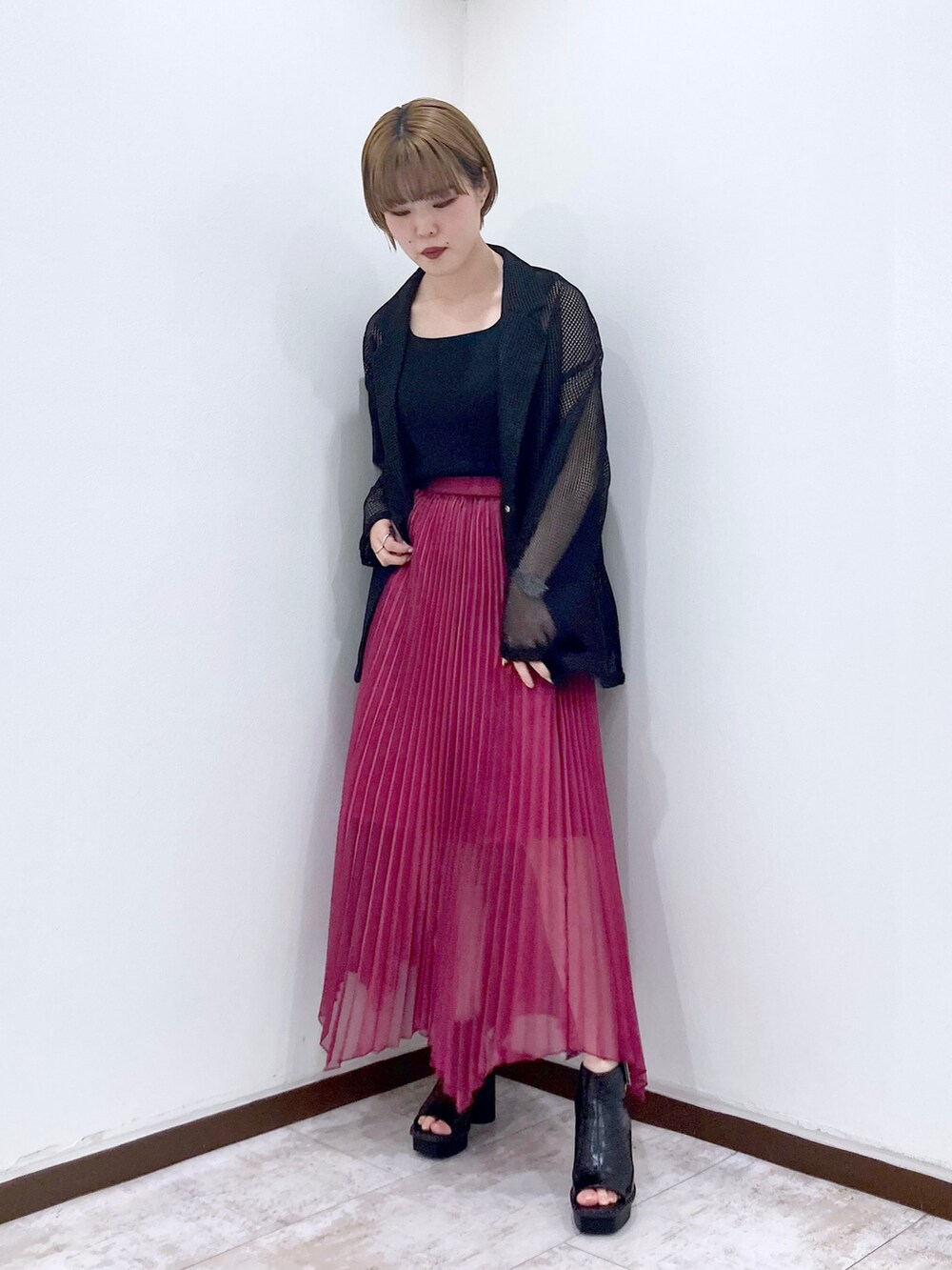 ピンク系のスカート、ブラック系のサンダル、ブラック系のタンクトップを着用したレディースの春コーディネートの3枚目の写真