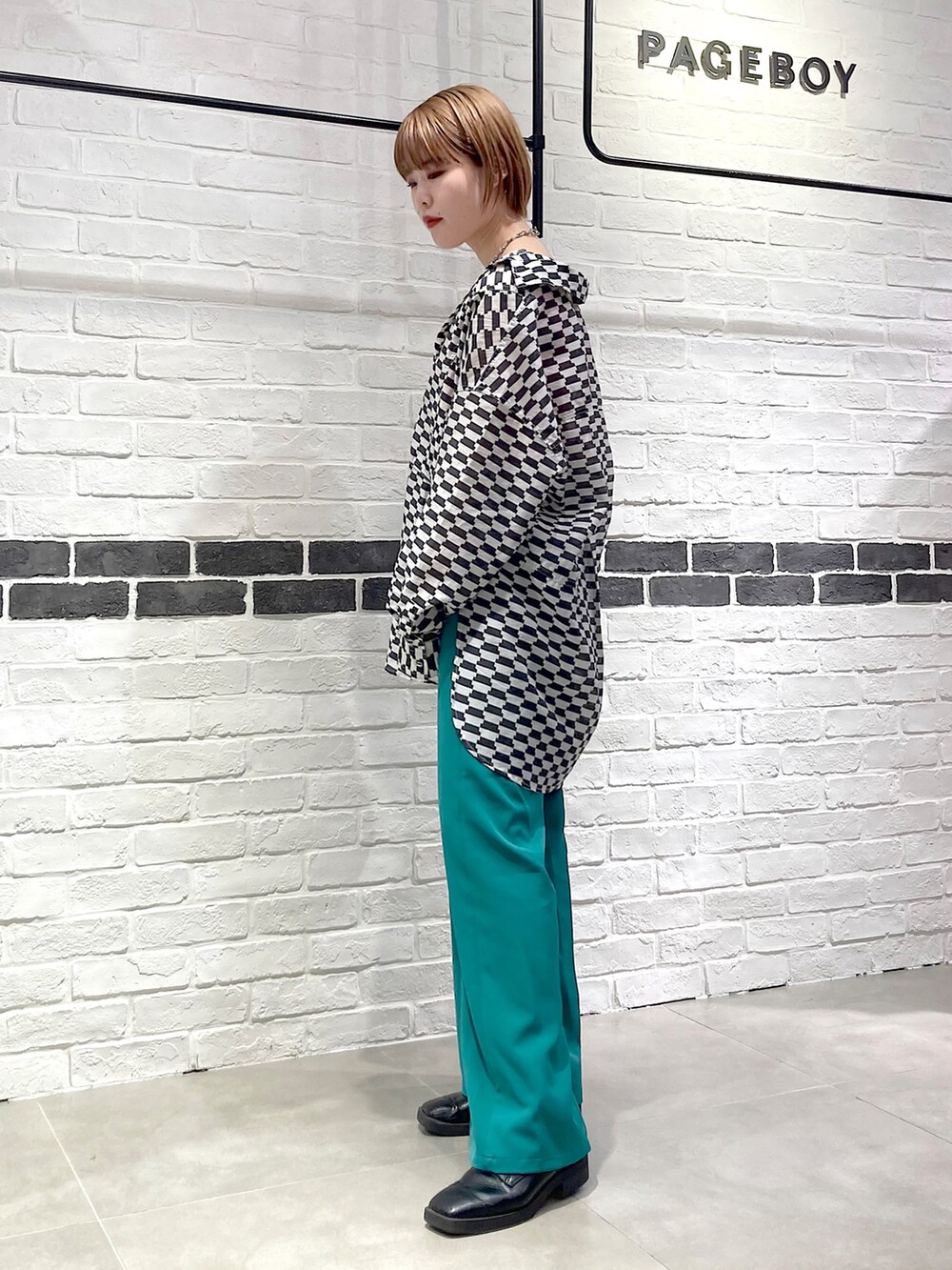 グリーン系のスラックス、ブラック系のシャツ/ブラウス、ピンク系のタンクトップを着用したレディースの春コーディネートの4枚目の写真