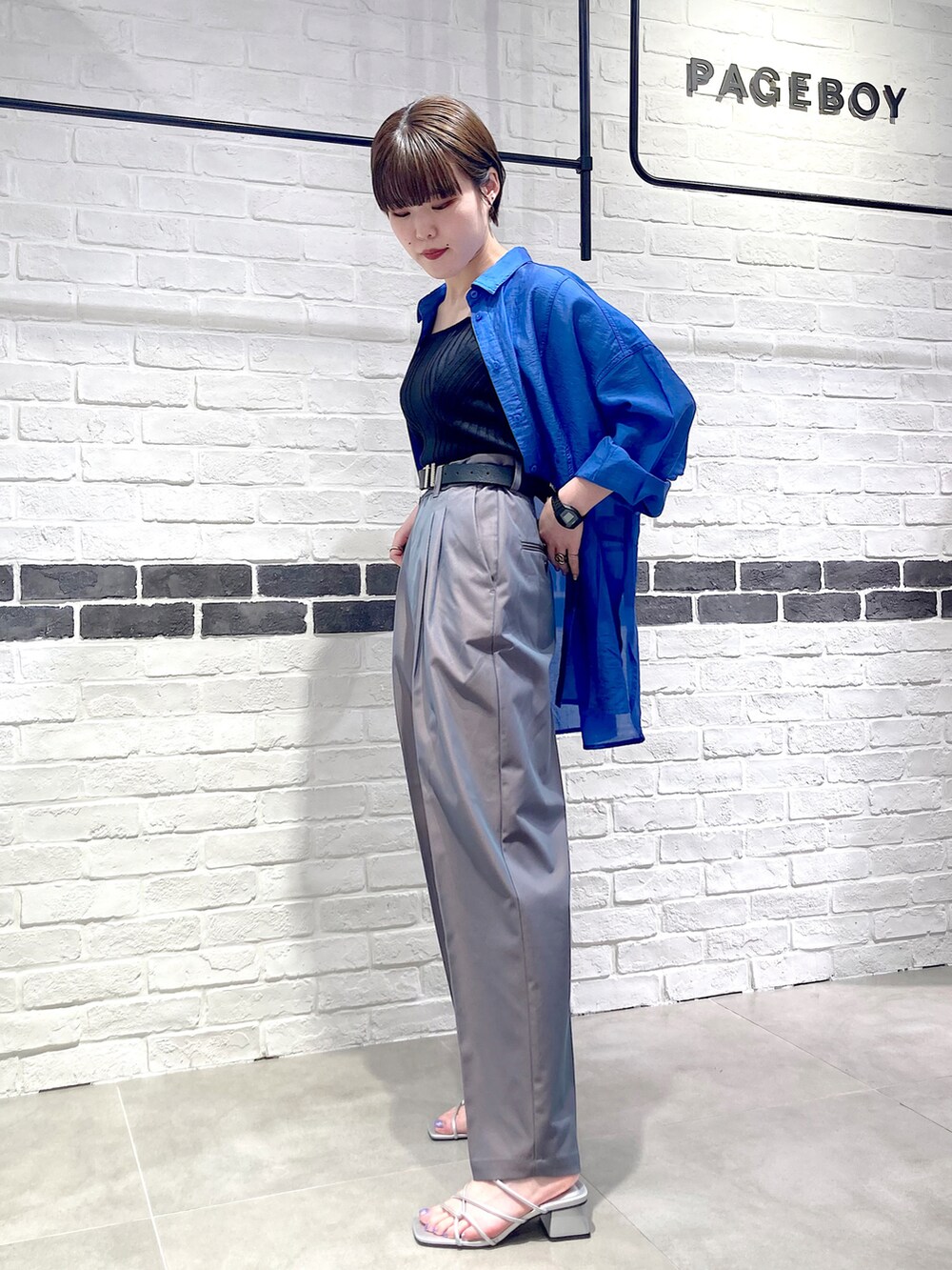 ブラック系のタンクトップ、ブルー系のシャツ/ブラウス、グレー系のスラックスを着用したレディースの夏コーディネートの4枚目の写真