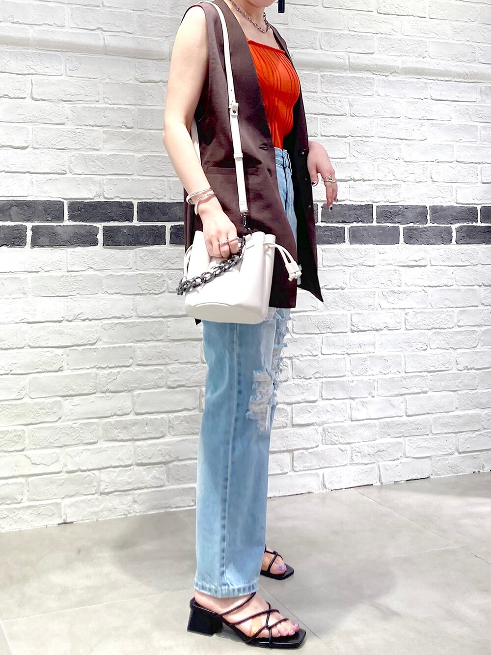 ブラック系のサンダル、ブルー系のデニムパンツ、ブラウン系のその他アウターを着用したレディースの夏コーディネートの5枚目の写真