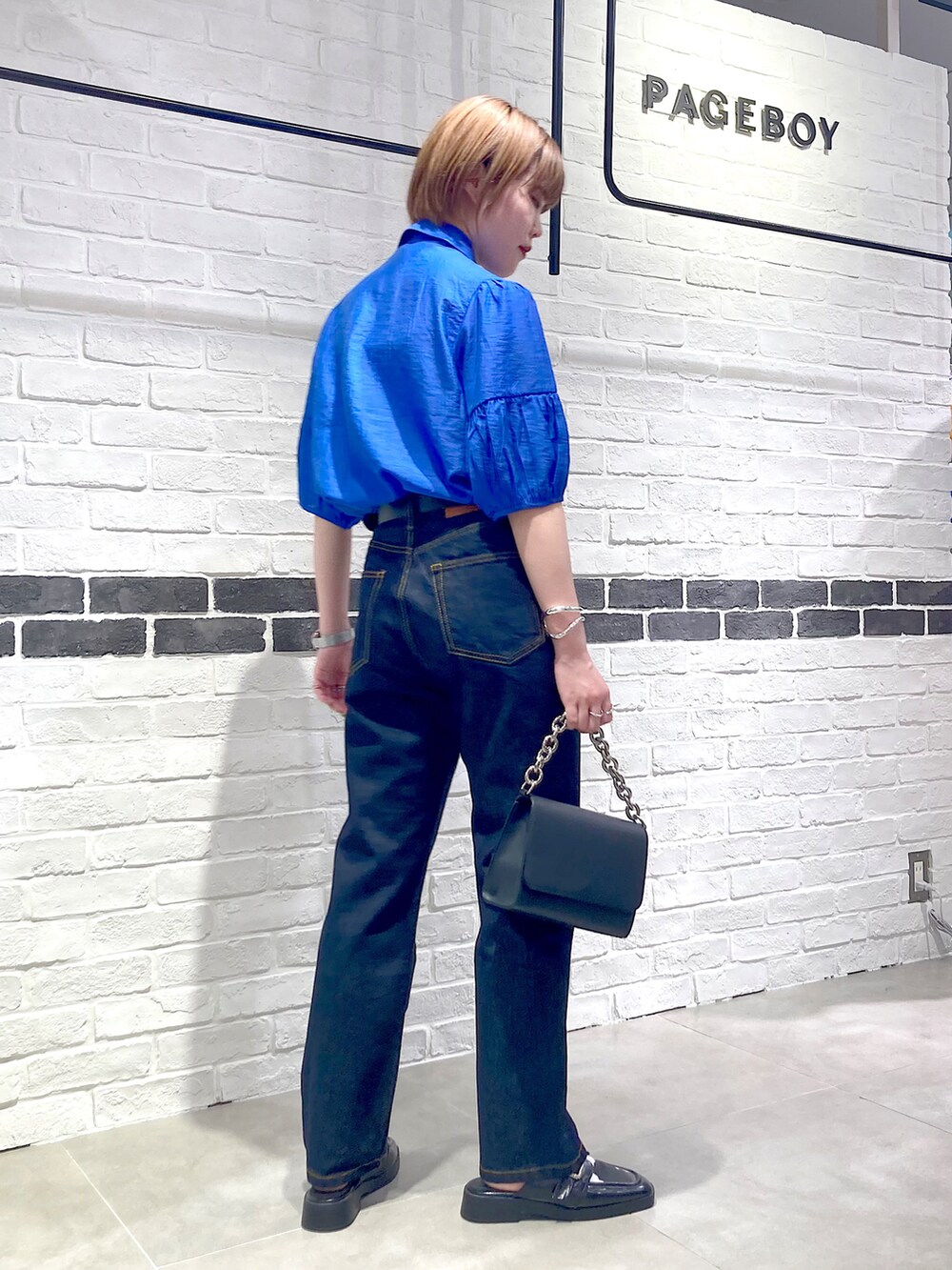 ブルー系のシャツ/ブラウス、ブラック系のショルダーバッグ、その他のローファーを着用したレディースの春コーディネートの4枚目の写真