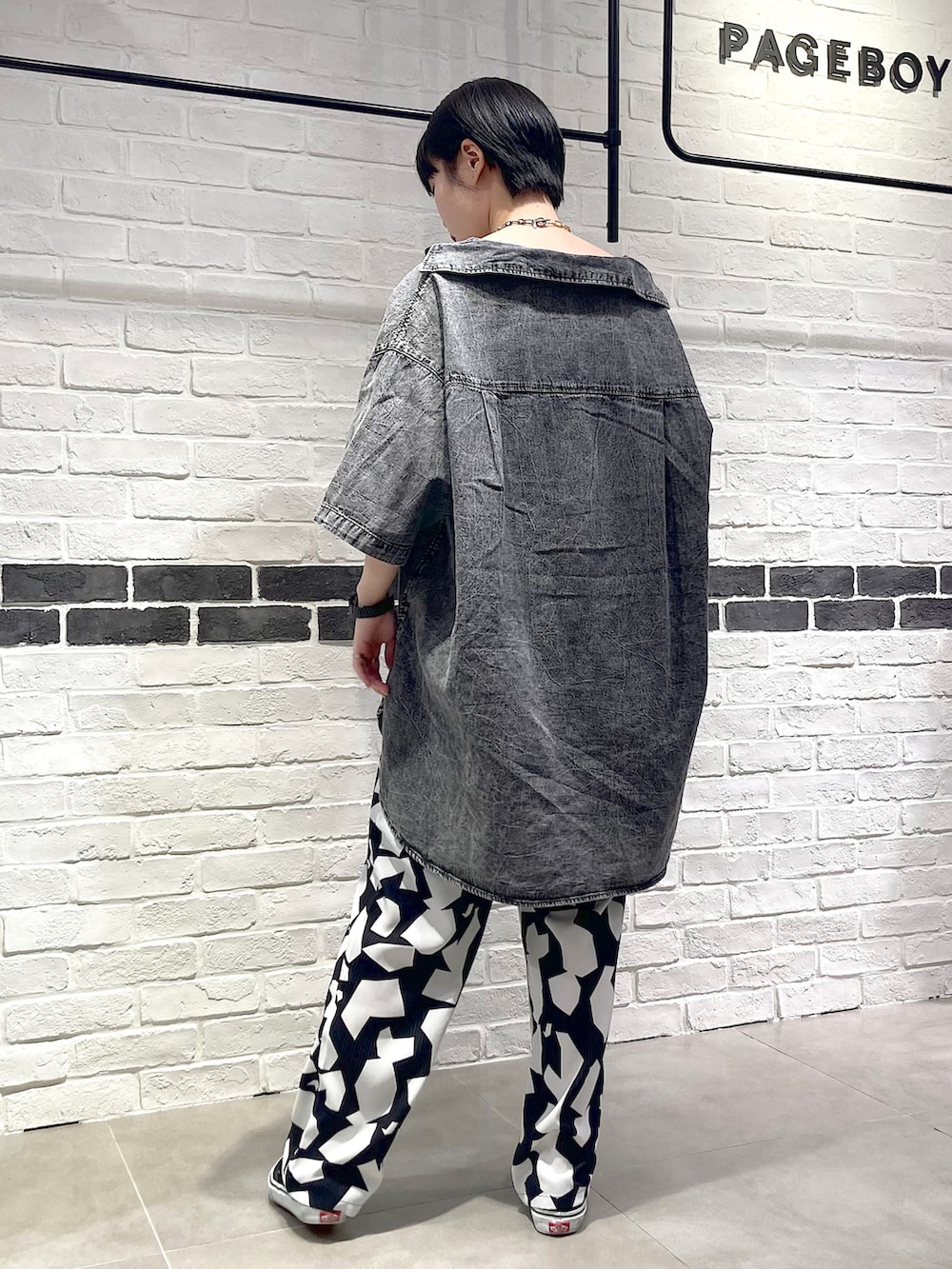 シルバー系のショルダーバッグ、ブラック系のシャツ/ブラウス、グリーン系のタンクトップを着用したレディースの夏コーディネートの4枚目の写真