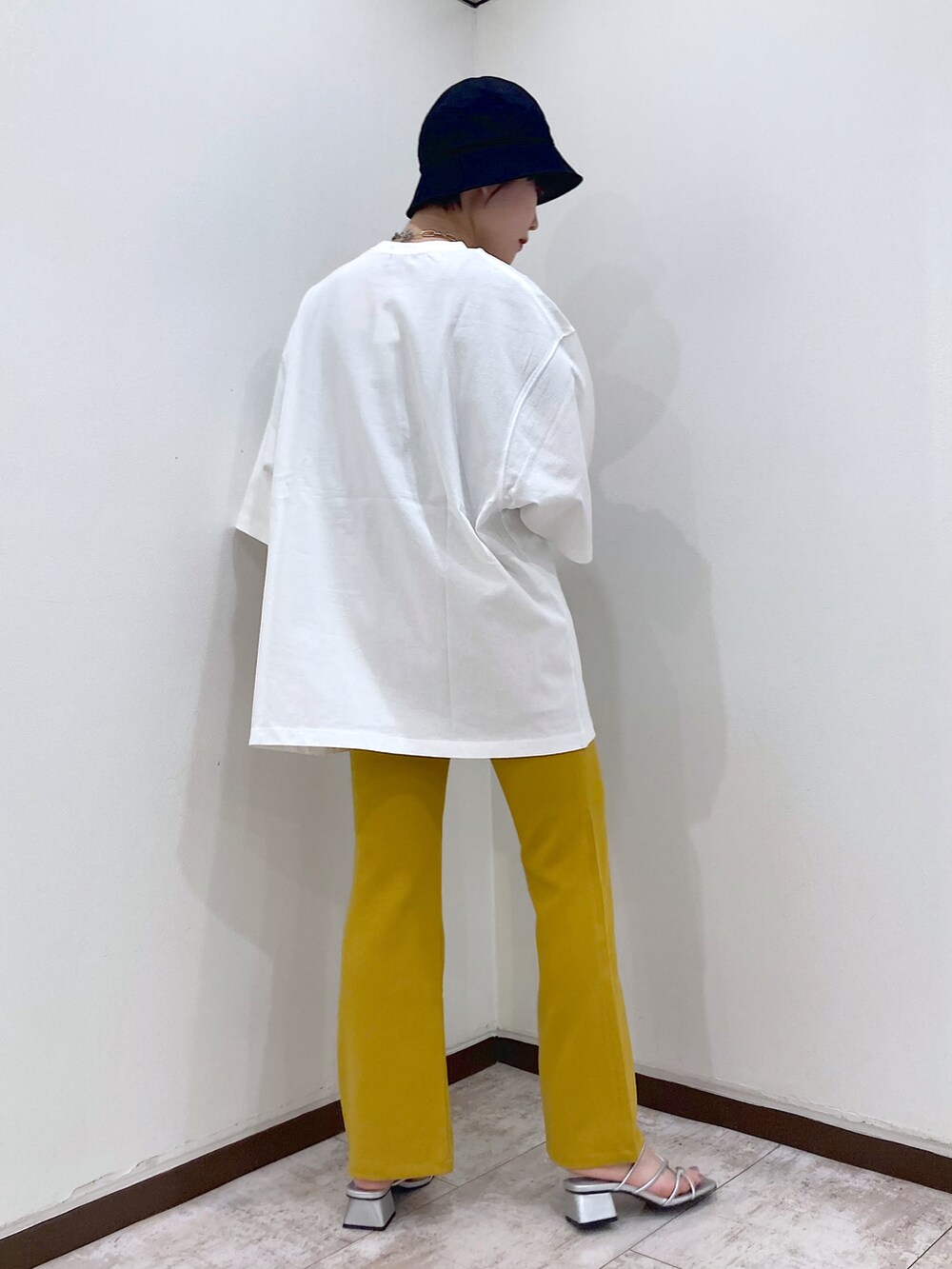 ホワイト系のTシャツ/カットソー、イエロー系のスラックス、シルバー系のサンダルを着用したレディースの夏コーディネートの5枚目の写真