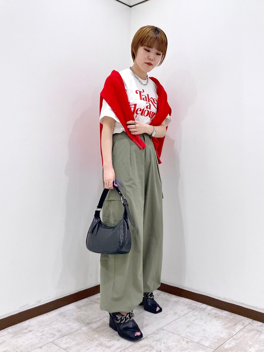 ホワイト系のTシャツ/カットソー、レッド系のカーディガン/ボレロ、グリーン系のカーゴパンツを着用したレディースの春コーディネートの2枚目の写真