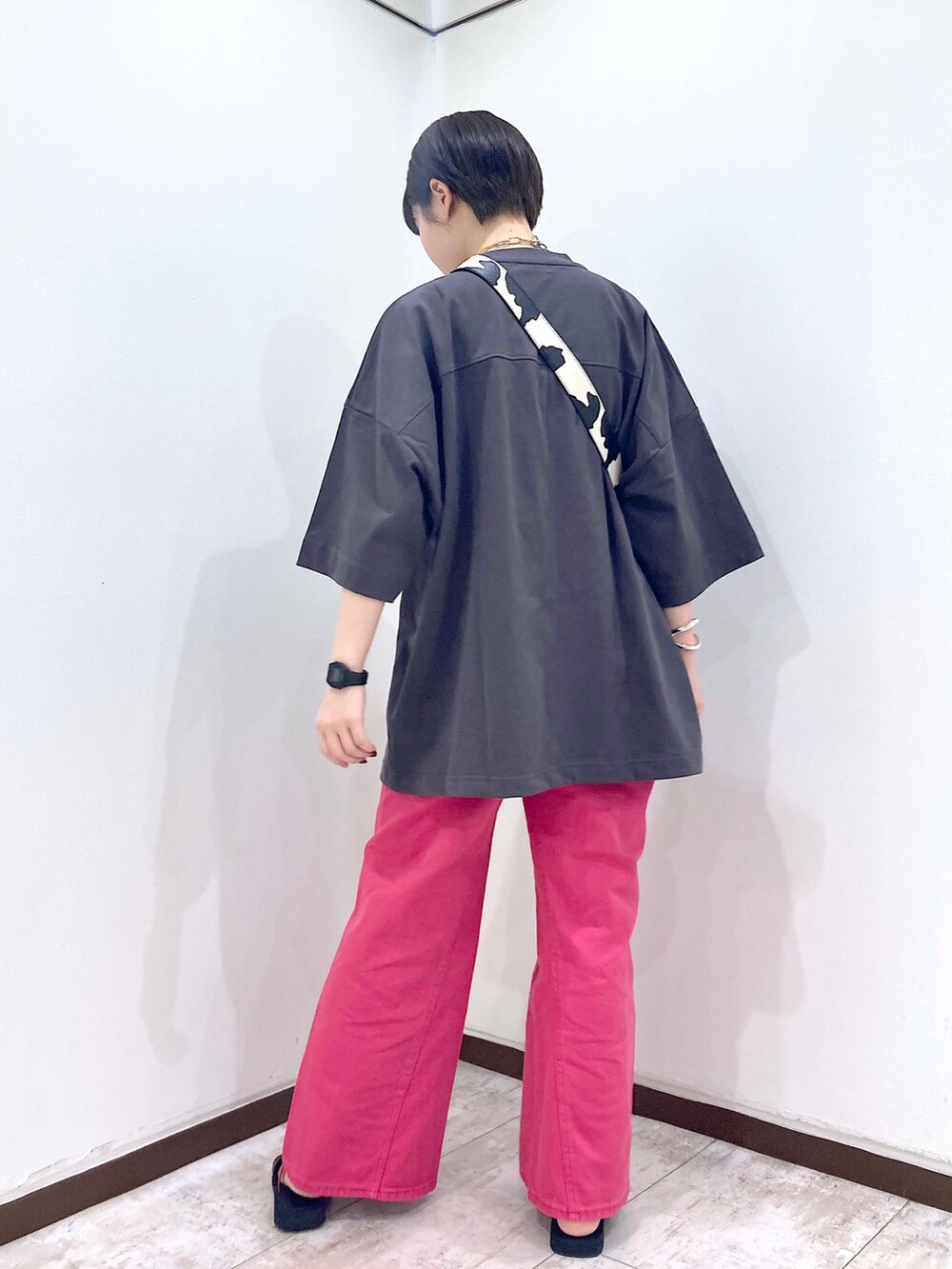 ピンク系のデニムパンツ、グレー系のTシャツ/カットソー、ホワイト系のショルダーバッグを着用したレディースの夏コーディネートの5枚目の写真