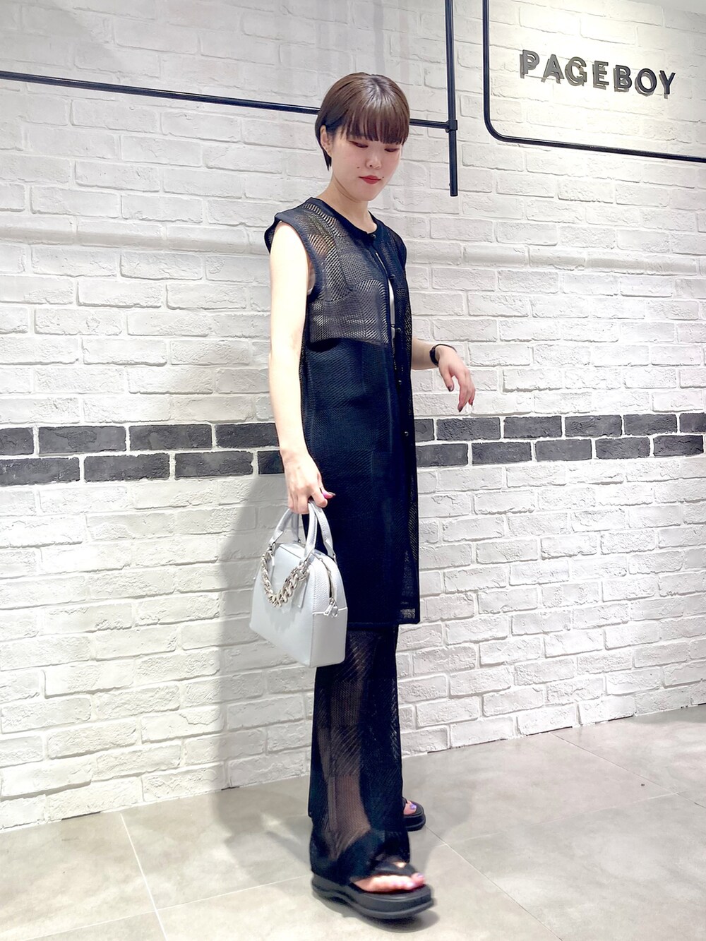 シルバー系のショルダーバッグ、ブラック系のその他パンツ、ブラック系のサンダルを着用したレディースの夏コーディネートの3枚目の写真